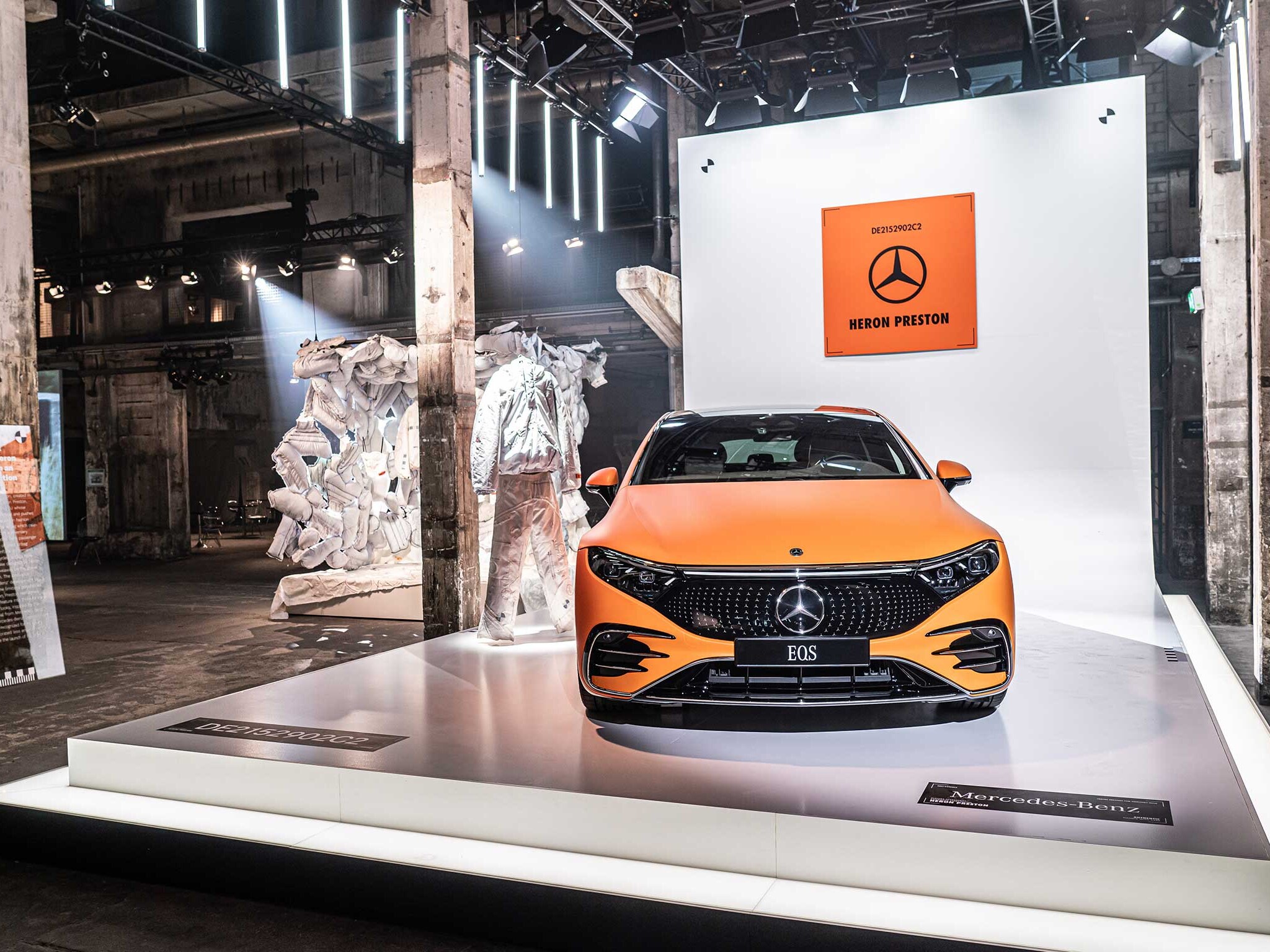 De foto toont een oranje Mercedes-Benz EQs