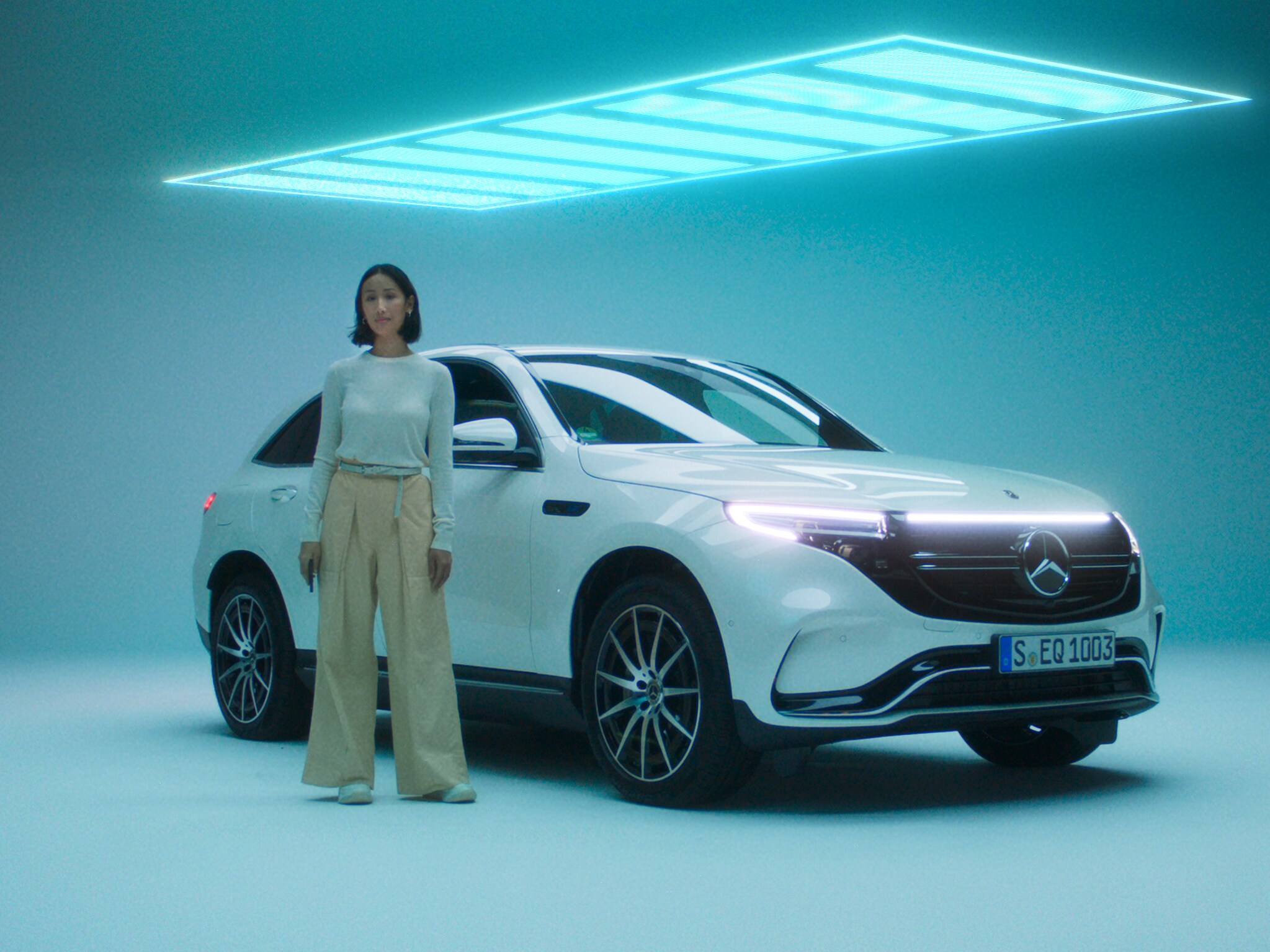Er staat een persoon voor een elektrisch Mercedes-Benz model