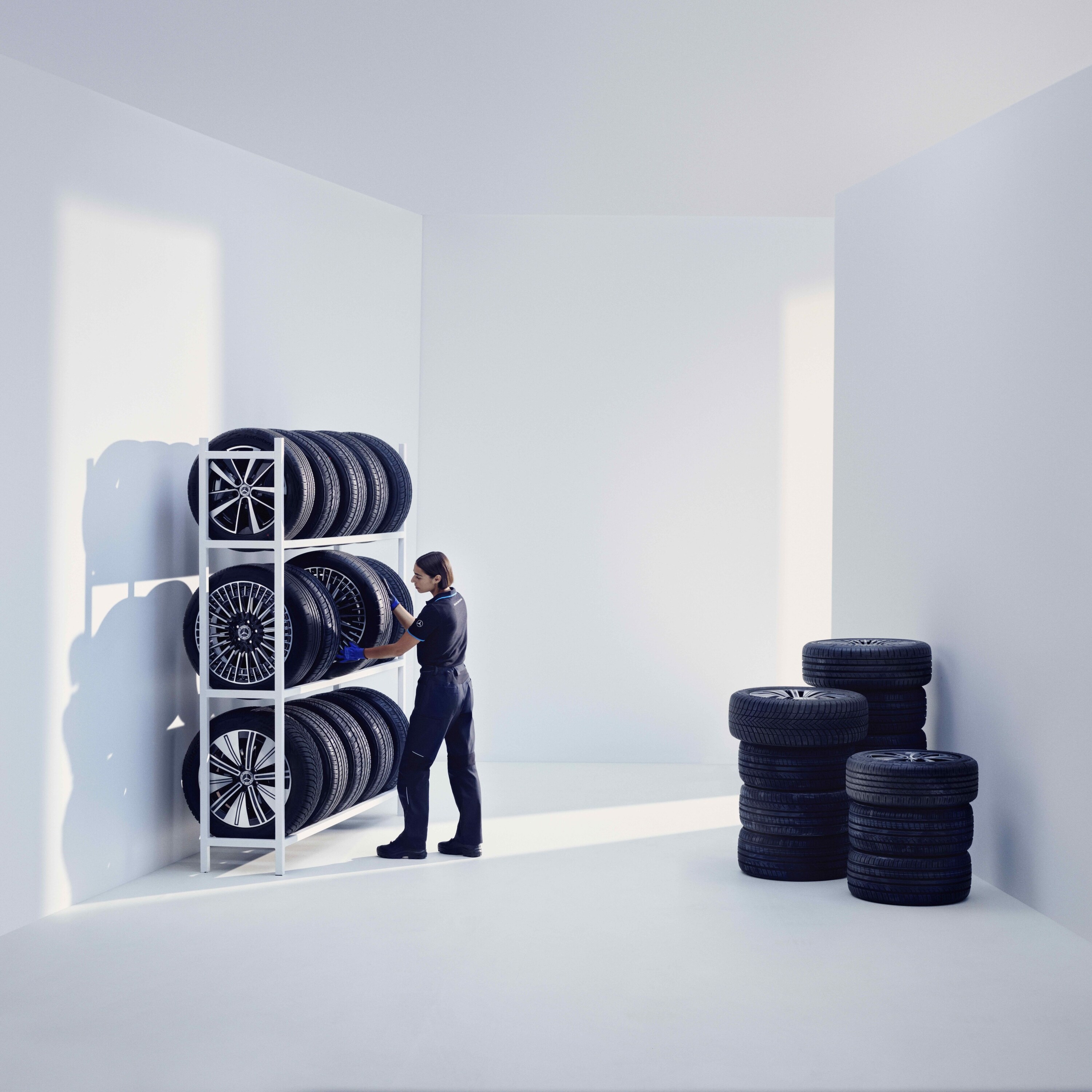 Een Mercedes-Benz technicus slaat originele Mercedes-Benz banden op een stellage op.