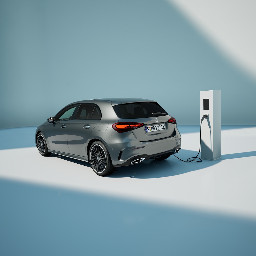 Zicht op een Mercedes-Benz A 250 e met EQ-hybridetechnologie, geparkeerd bij een laadstation.