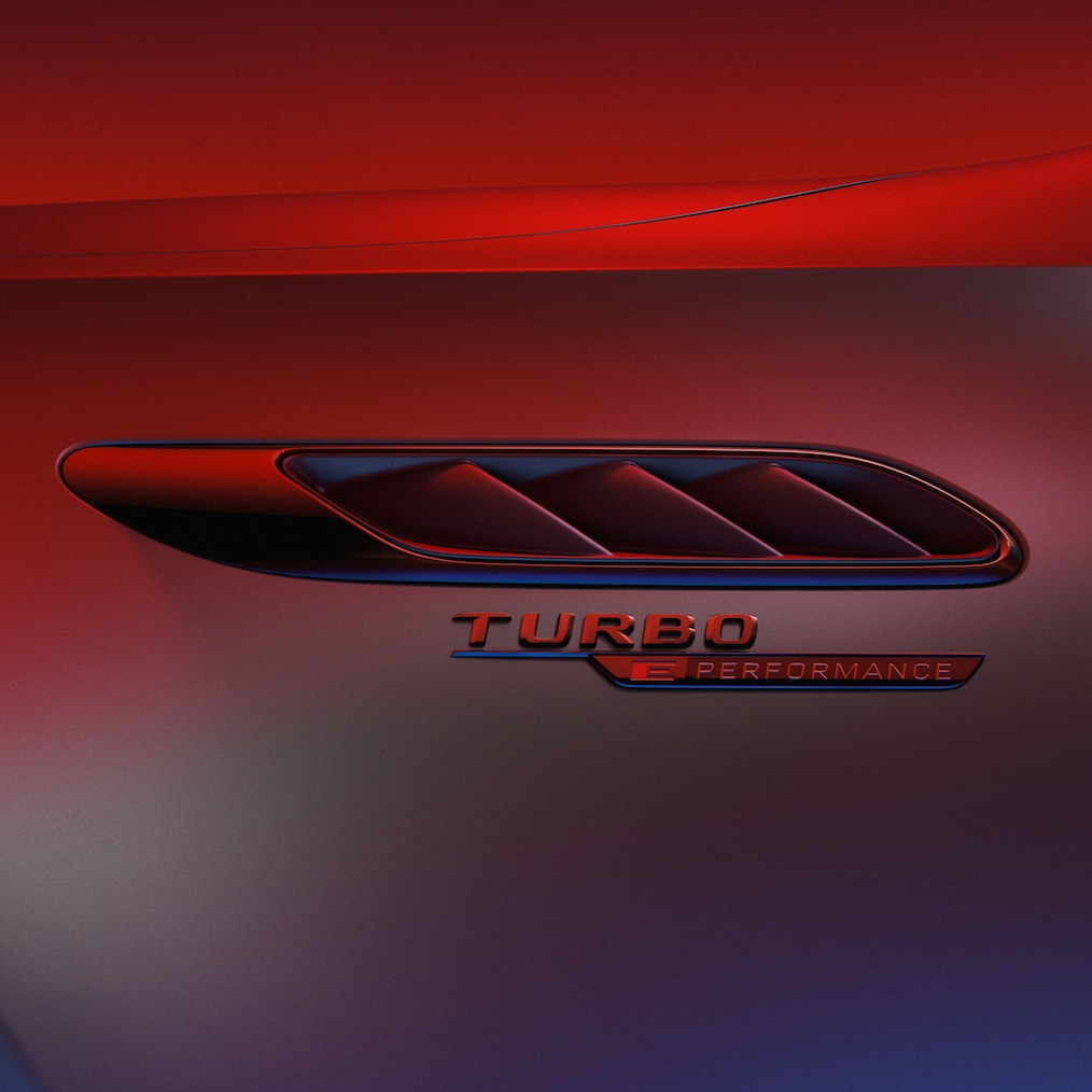 TURBO E PERFORMANCE-badge op de voorspatscherm, verlicht door rood licht.