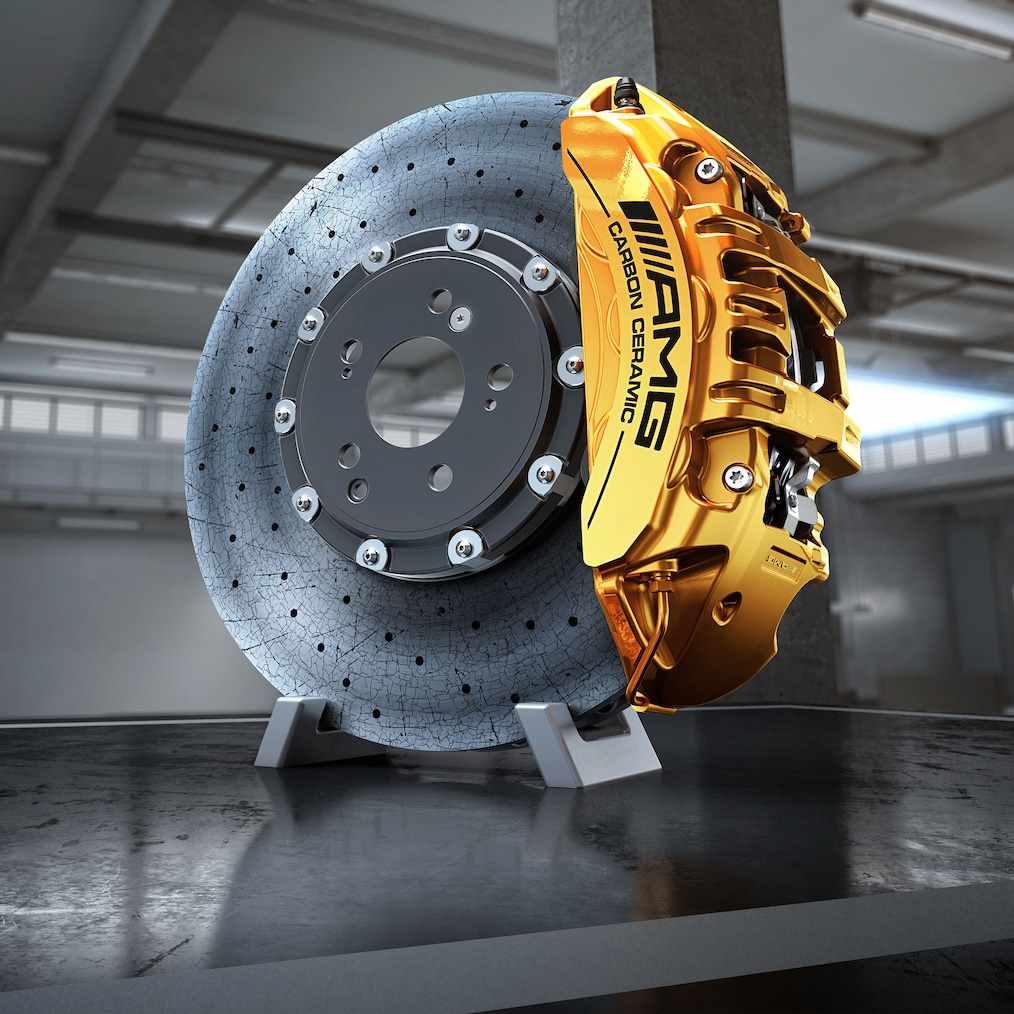Close-up van een AMG lichtmetalen velg met AMG high-performance keramisch composiet remsysteem dat erdoorheen schijnt.