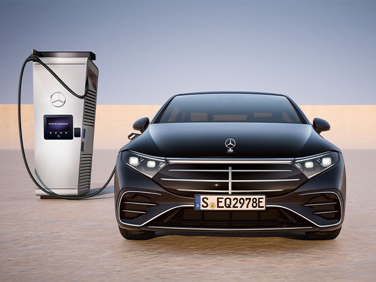 Vooraanzicht van de EQS Limousine van Mercedes-Benz die bij een publiek oplaadpunt wordt opgeladen.