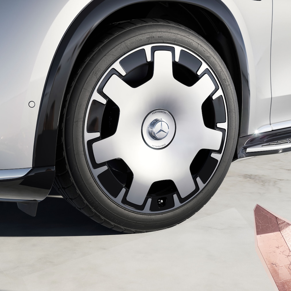 Close-up van het linker voorwiel (55,9 cm (22-inch) Maybach 7-gaatjes lichtmetalen velgen 06R).