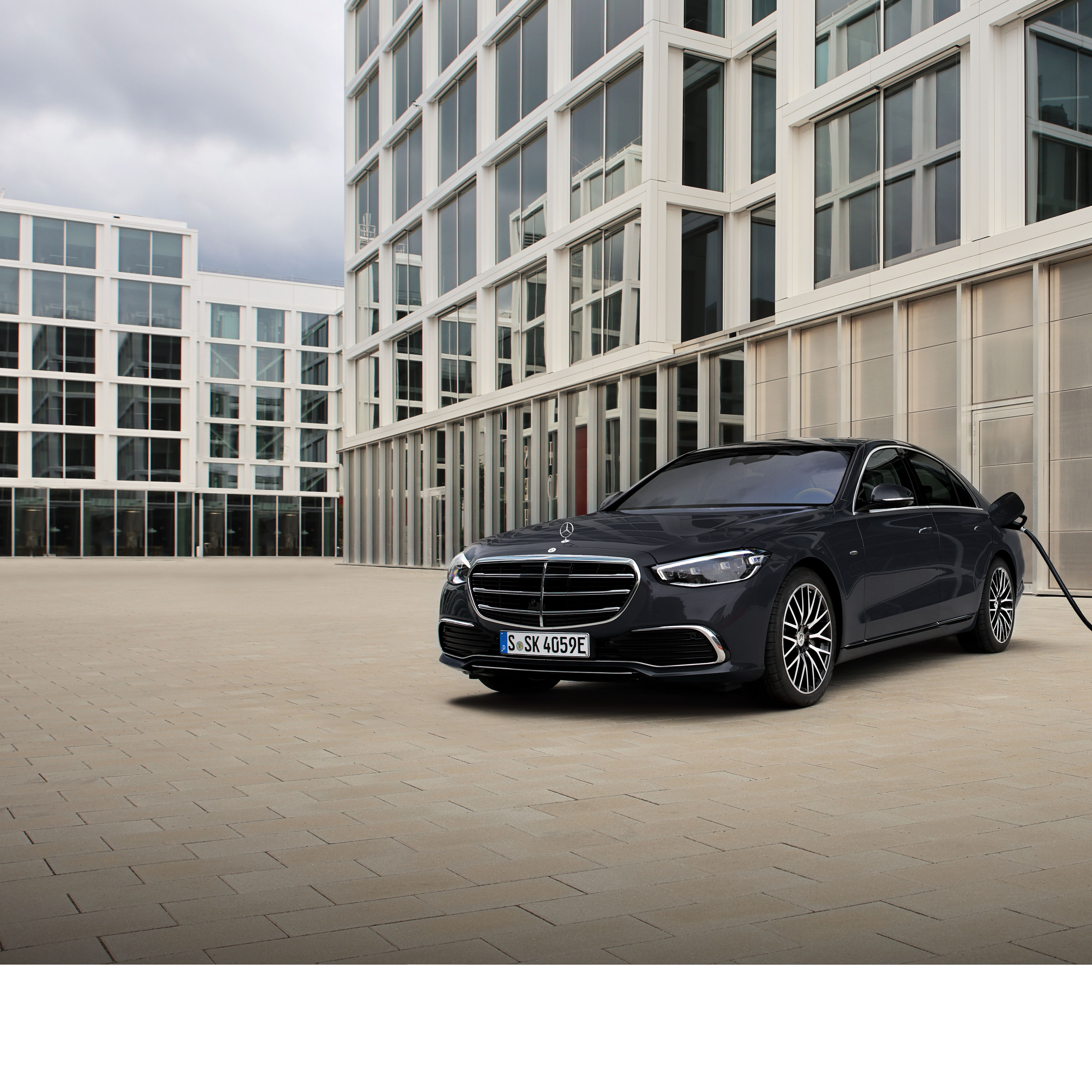 Mercedes-Benz: Expatriate Services Het beeld toont een Mercedes-Benz E-Klasse op een parking met op de achtergrond gebouwen.