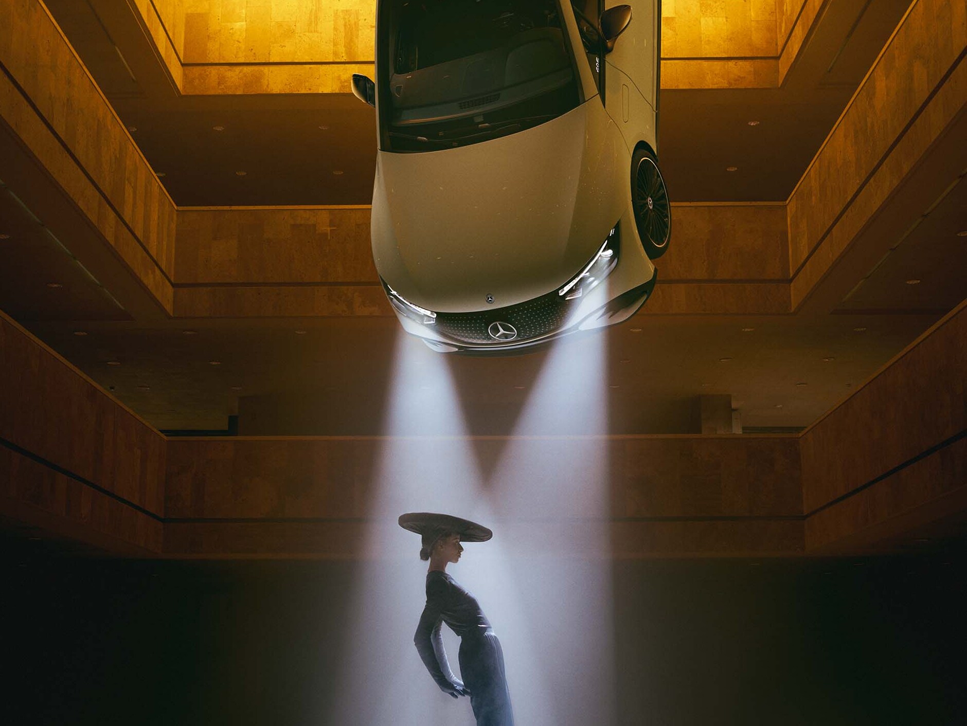 Een donkere ruimte waarin een vrouw in de lichtstraal staat van spots die aan het plafond hangen.