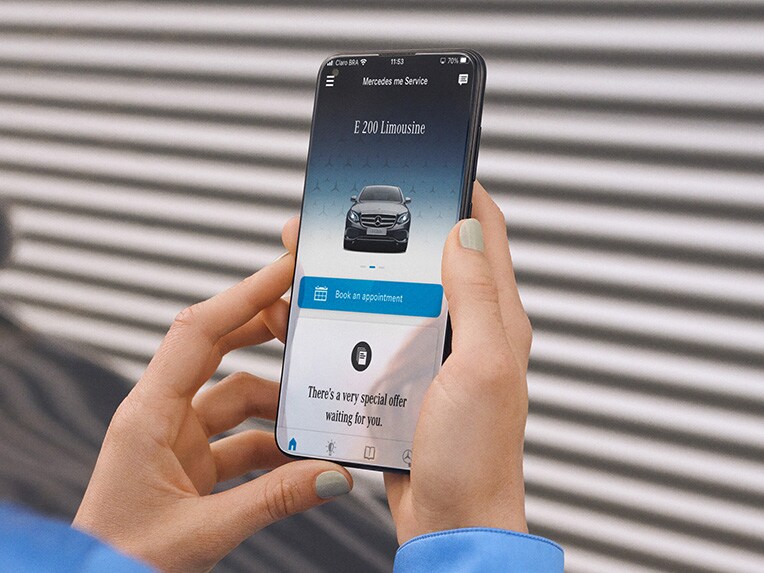 Een smartphone en een detailaanzicht van de koplamp van een Mercedes-Benz.