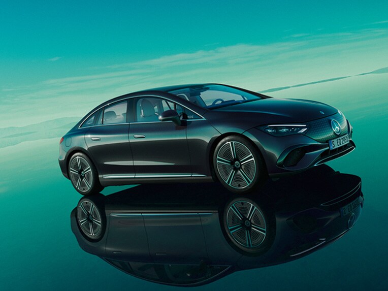 De volledig elektrische Mercedes EQE in zijn groene EQ-wereld met spiegelende ondergrond.
