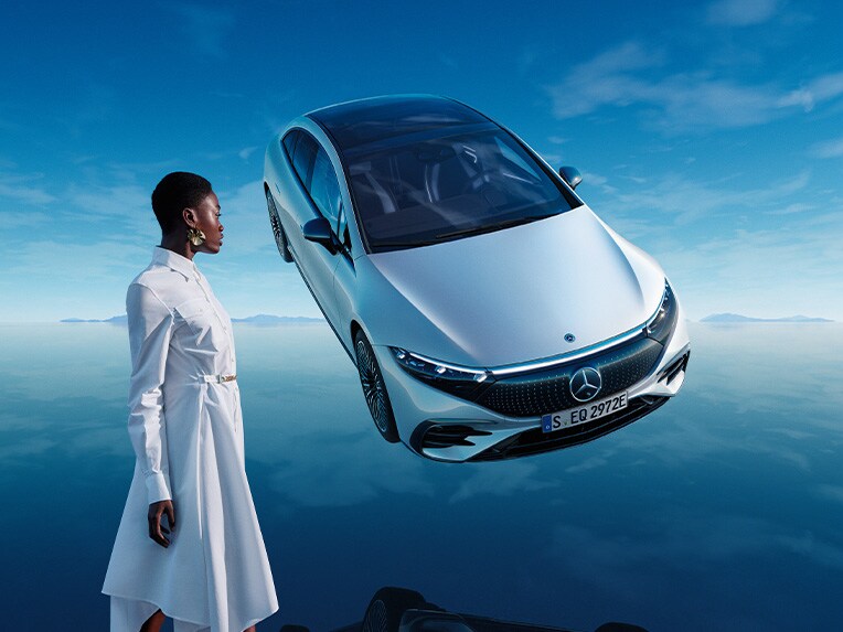 De volledig elektrische Mercedes EQS in zijn blauwe EQ-wereld met spiegelende ondergrond.