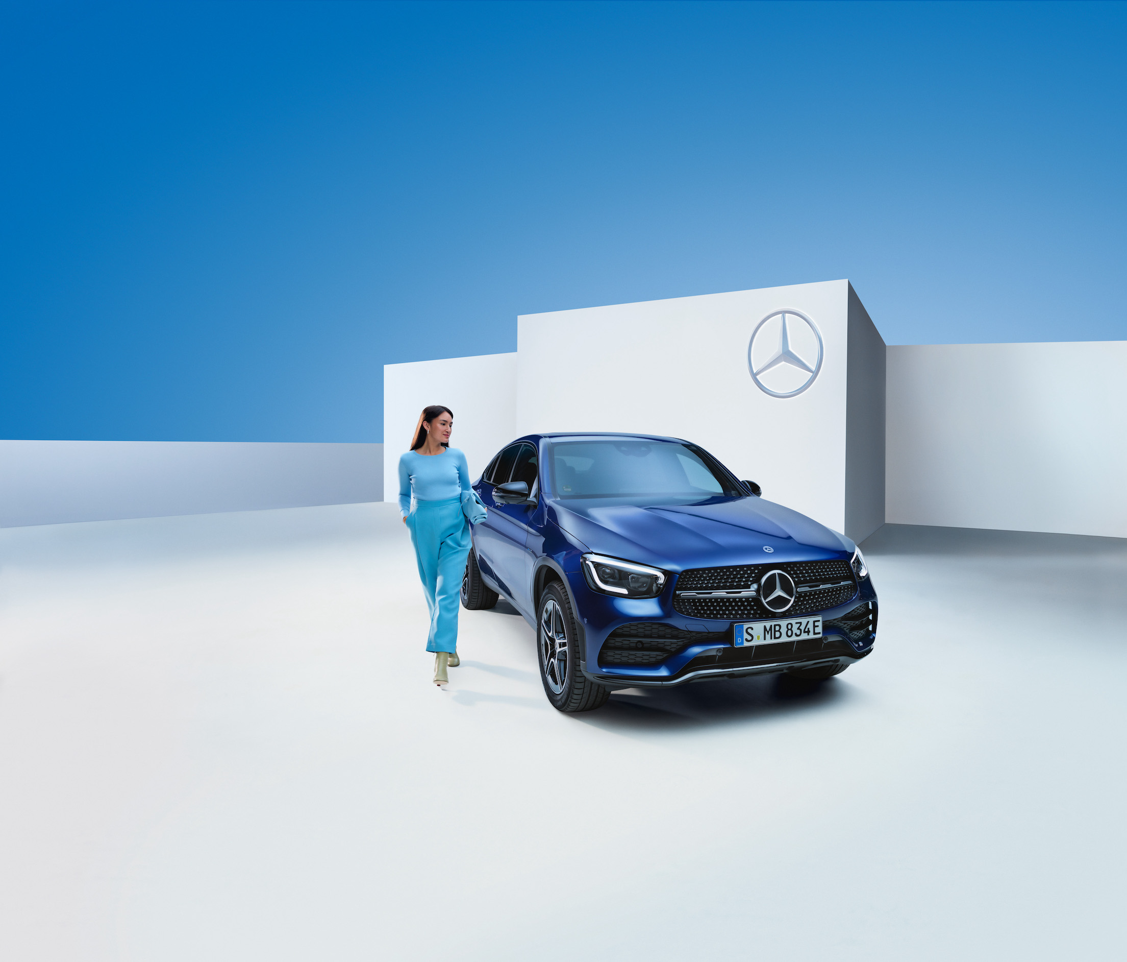 Mercedes-Benz | Originele verzorgingsproducten Een vrouw staat naast haar Mercedes-Benz.