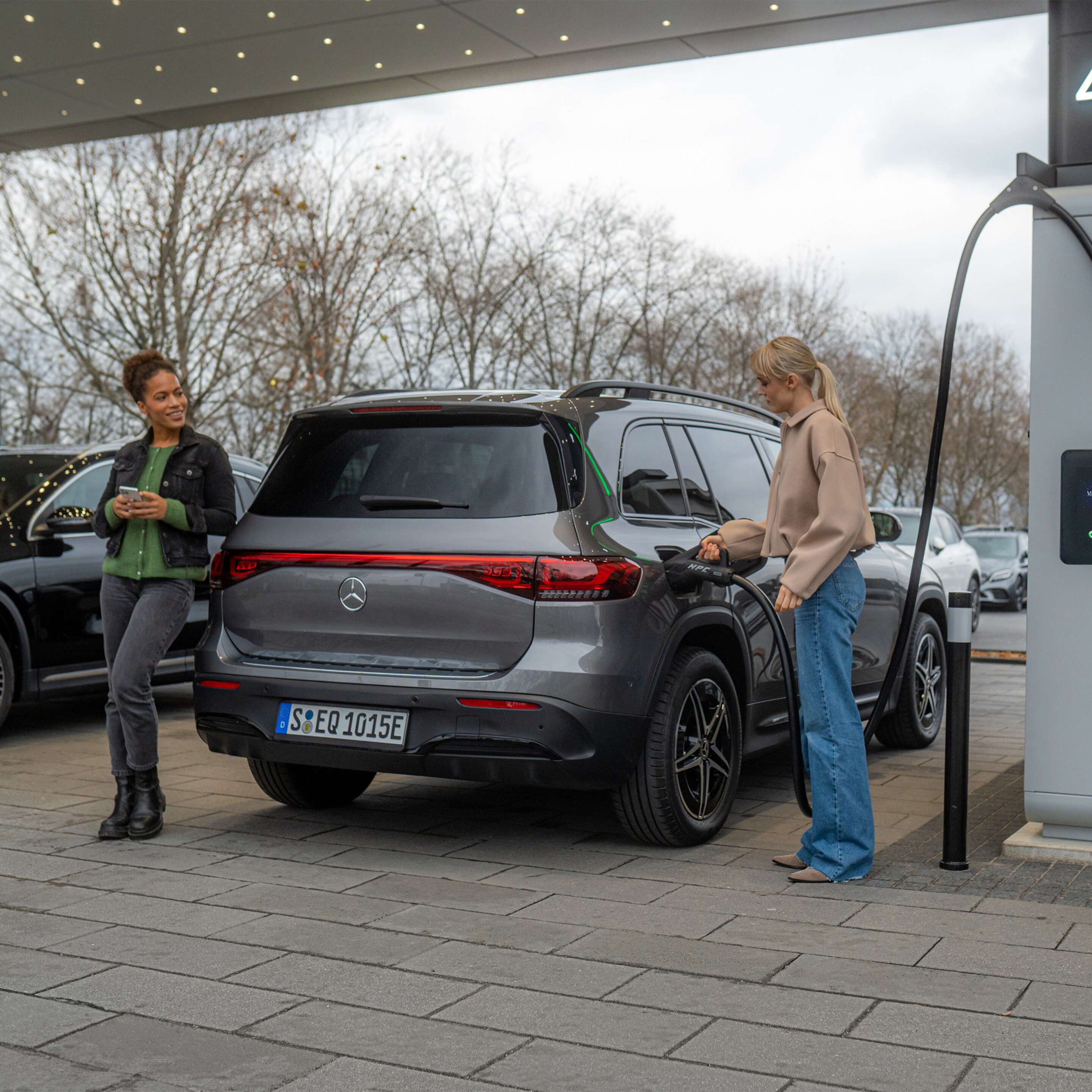 Twee elektrische modellen van Mercedes-Benz bij een oplaadpunt.