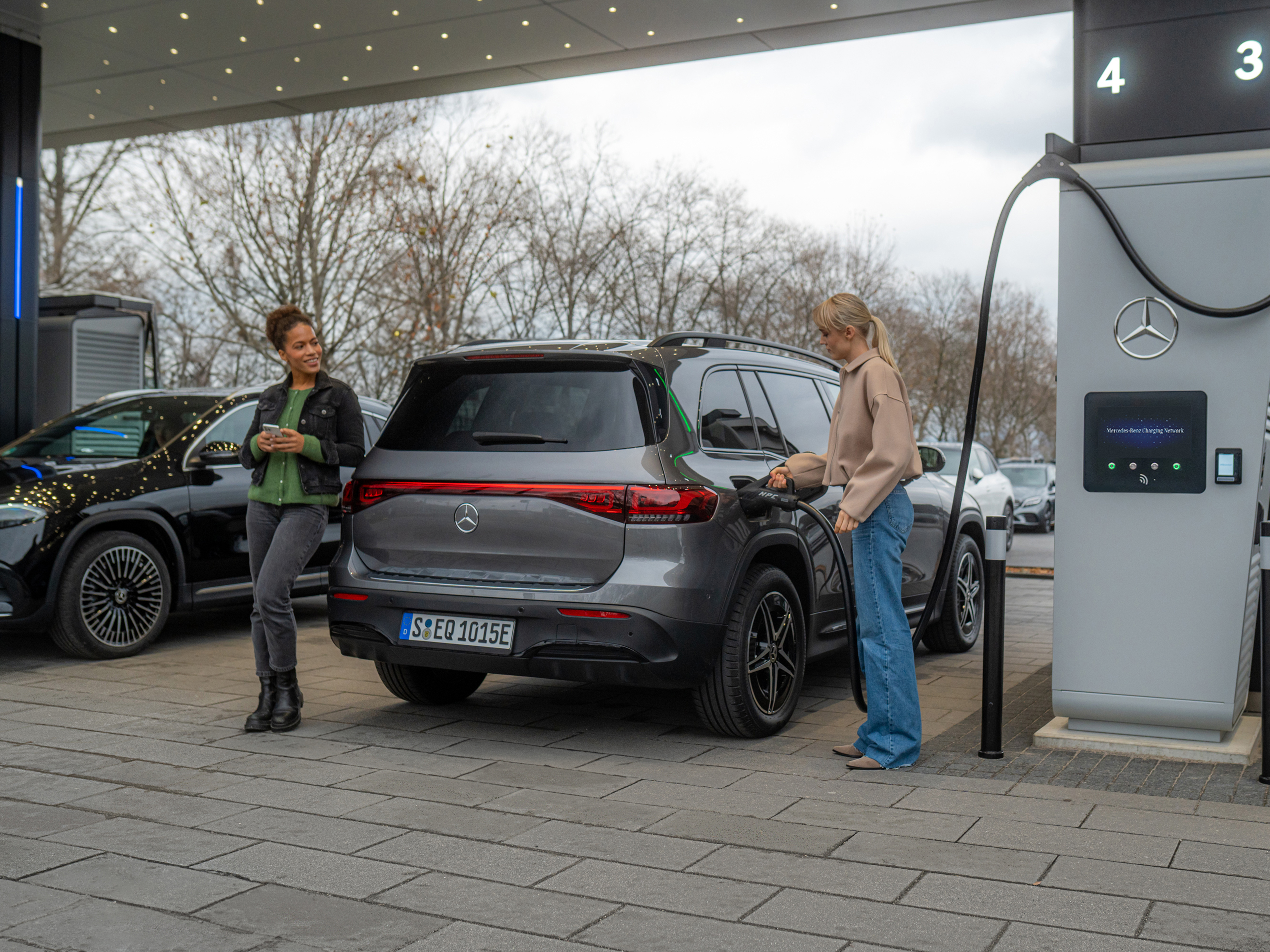 Mercedes-Benz oplaadnetwerk | Onderweg opladen | Mercedes-Benz Twee elektrische modellen van Mercedes-Benz bij een oplaadpunt.