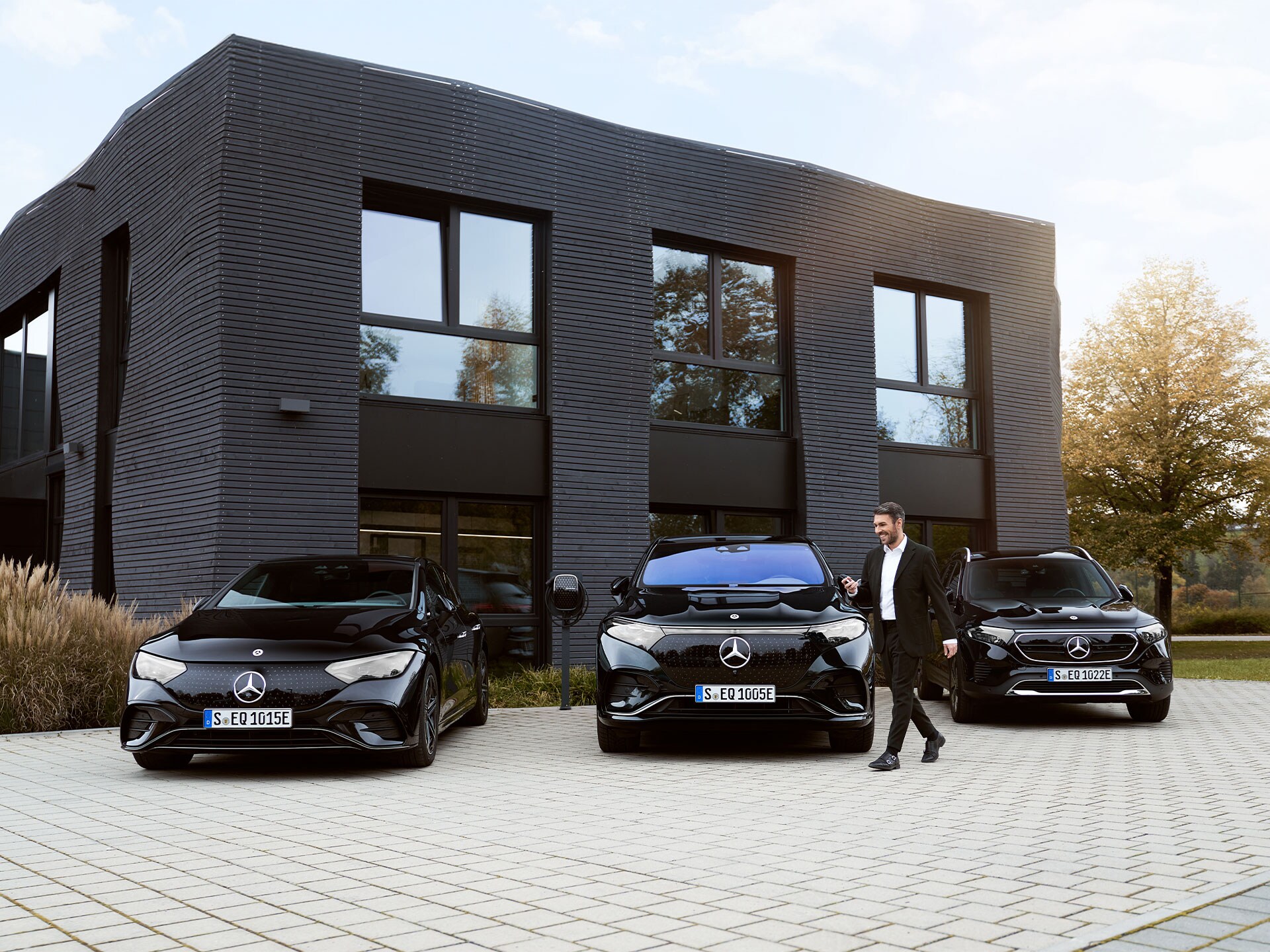 Drie elektrische Mercedes-Benz auto's voor een kantoorgebouw.