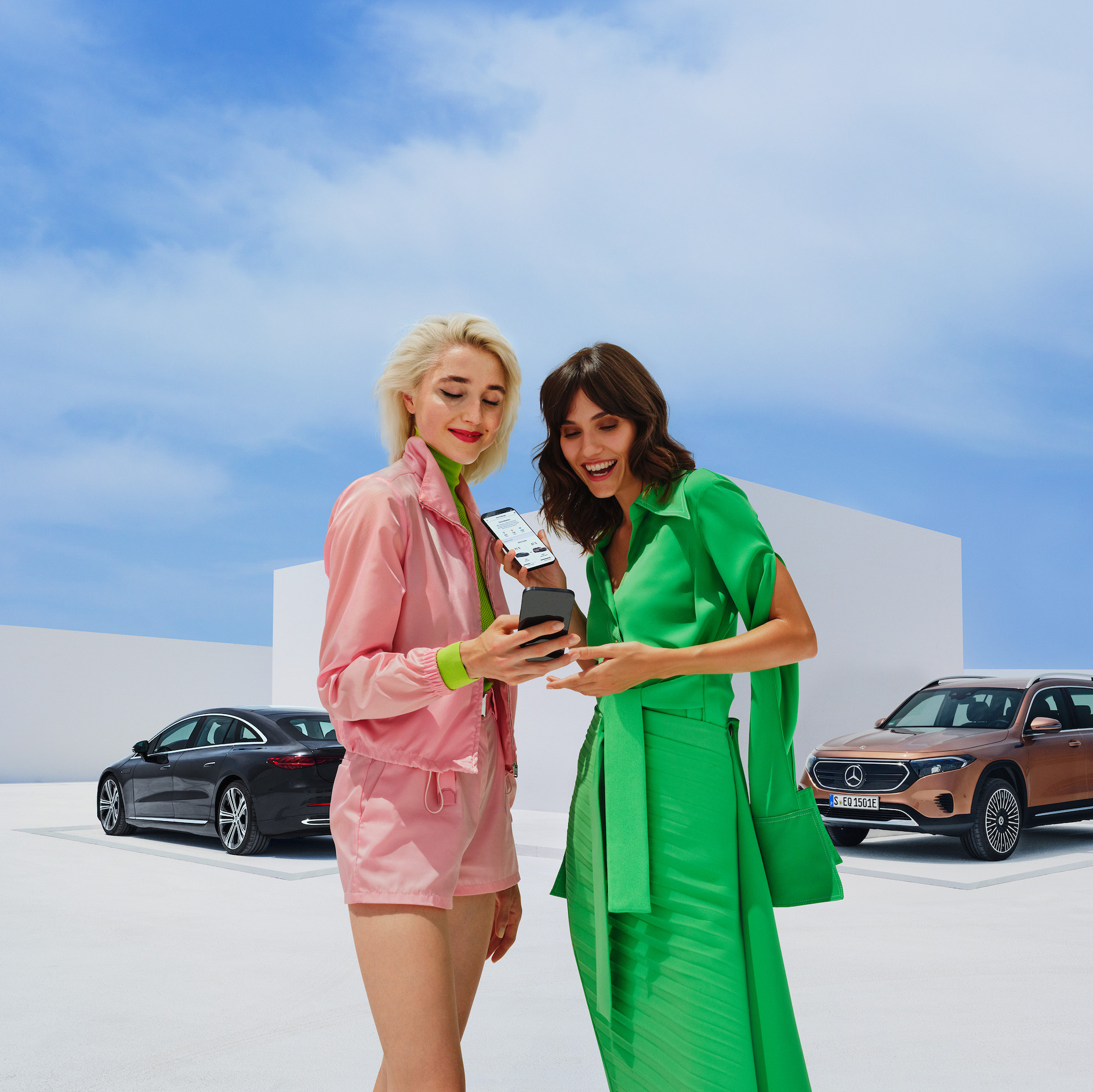 Mercedes-Benz Service-app Twee vrouwen gebruiken de Mercedes-Benz Service-app op hun smartphones.