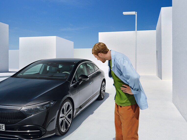 Een man vóór een Mercedes-Benz.