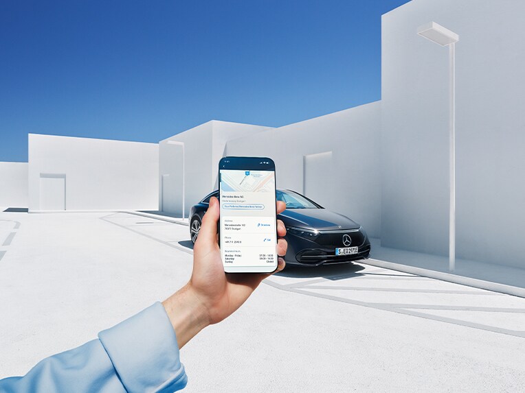 Iemand houdt een smartphone vast die via digitale extra's met een Mercedes-Benz is verbonden.
