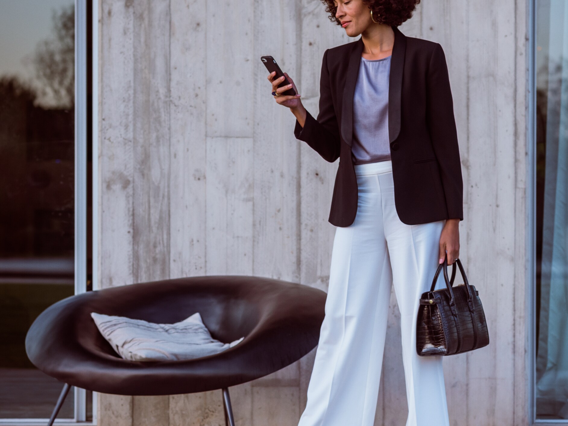Een vrouw brengt via haar smartphone, de Mercedes me App en haar Mercedes me ID een verbinding tot stand met haar Mercedes Benz.