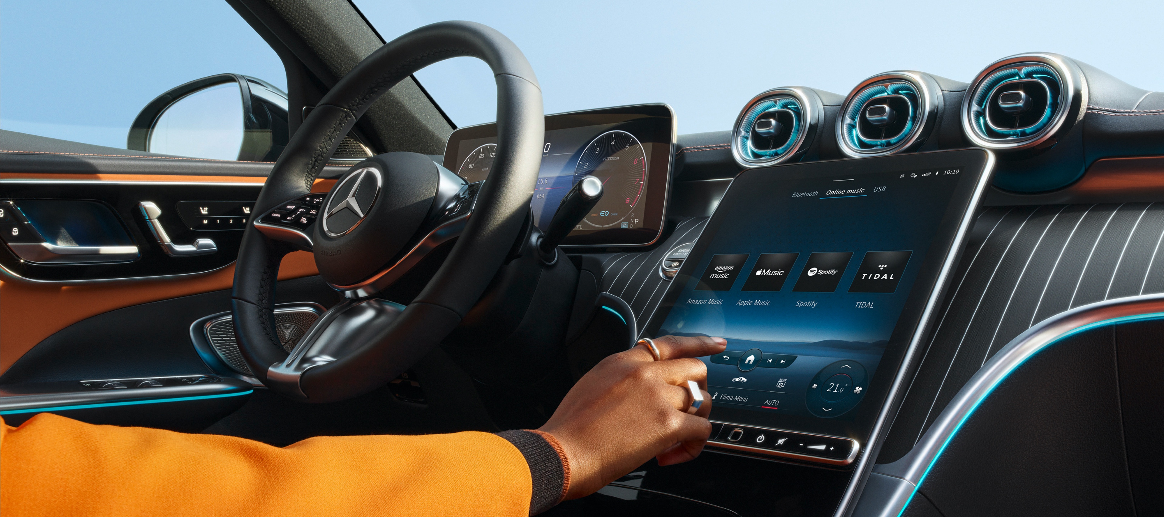 Een persoon kiest op het MBUX-multimediasysteem in een Mercedes-Benz uit de audiostreamingdiensten Amazon Music, Apple Music, Spotify en TIDAL de gewenste streamingdienst. Een persoon kiest op het MBUX-multimediasysteem in een Mercedes-Benz uit de audiostreamingdiensten Amazon Music, Apple Music, Spotify en TIDAL de gewenste streamingdienst.