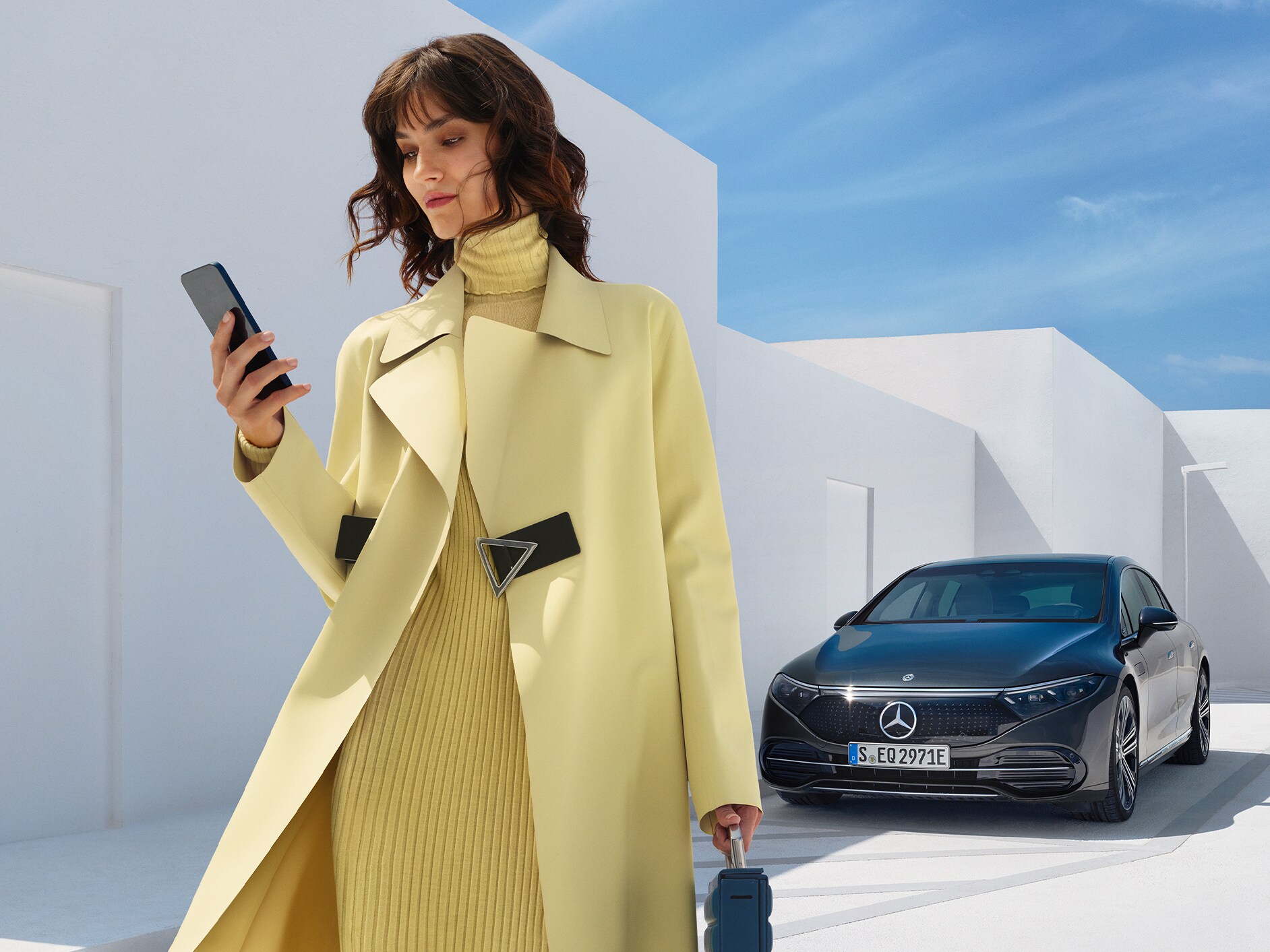 De afbeelding toont een vrouw vóór de EQS Limousine van Mercedes-EQ.