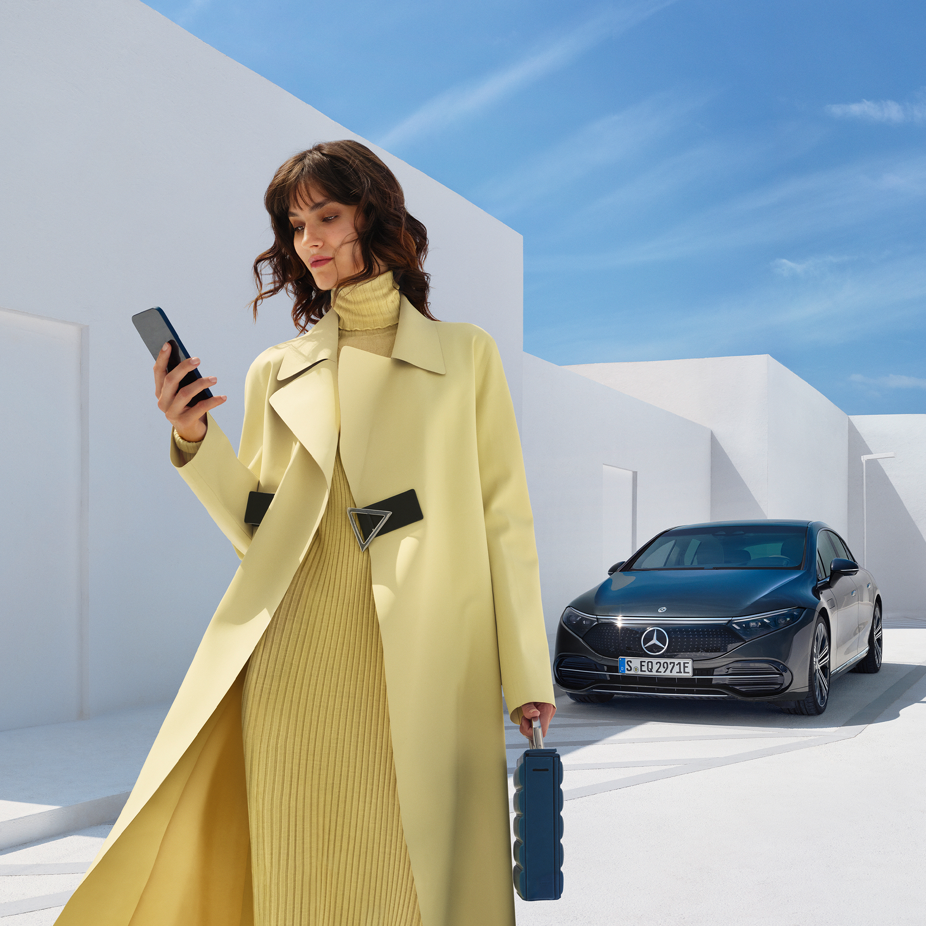 Digitale extra's kopen | Remote | Mercedes me De afbeelding toont een vrouw vóór de EQS Limousine van Mercedes-EQ.