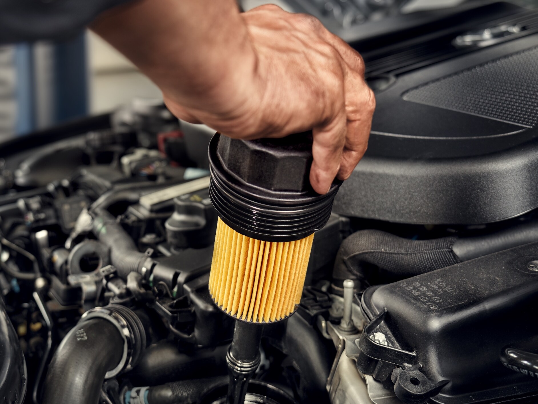 Een monteur installeert het oliefilter op het Mercedes-Benz voertuig.