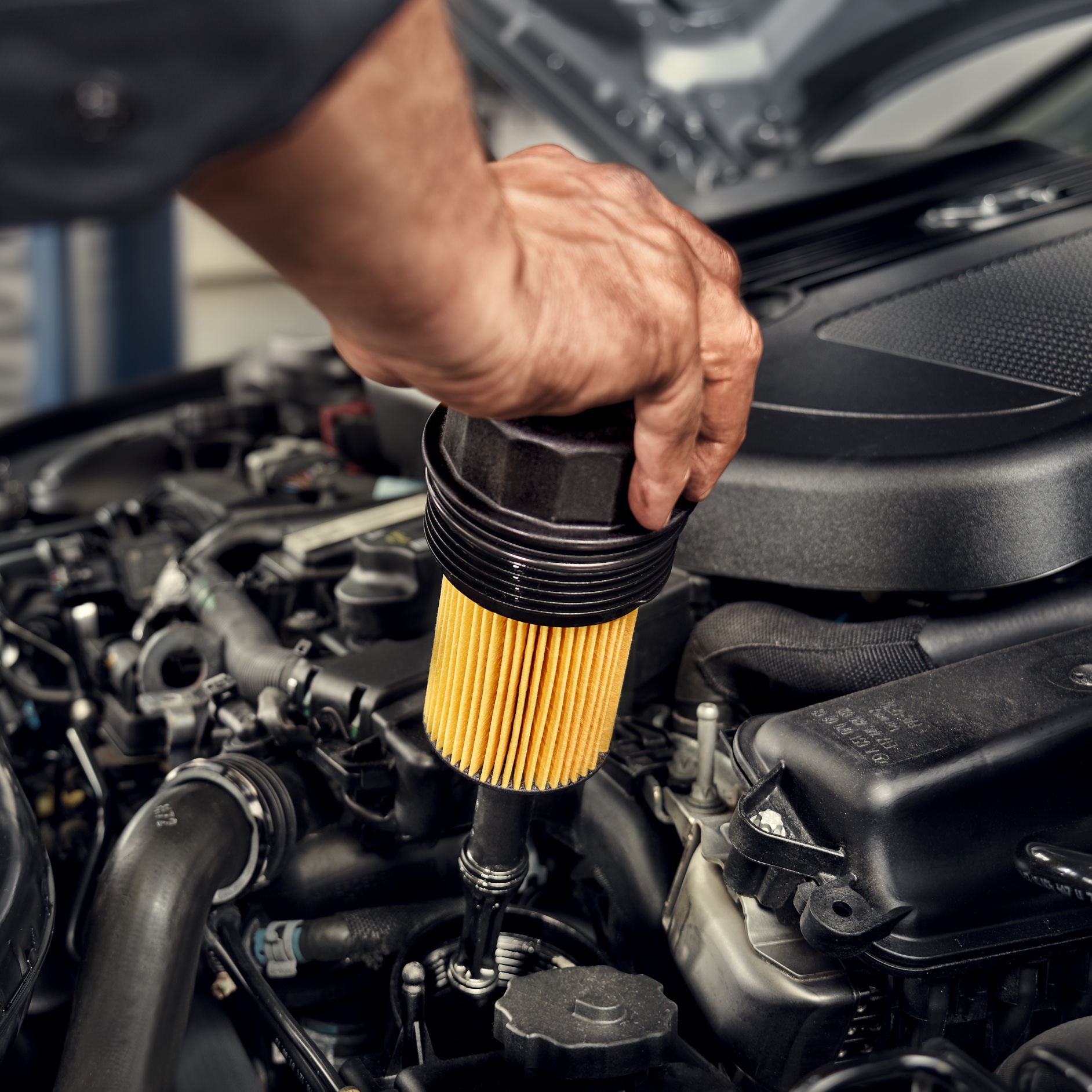Oliefilter | Mercedes-Benz Een monteur installeert het oliefilter op het Mercedes-Benz voertuig.