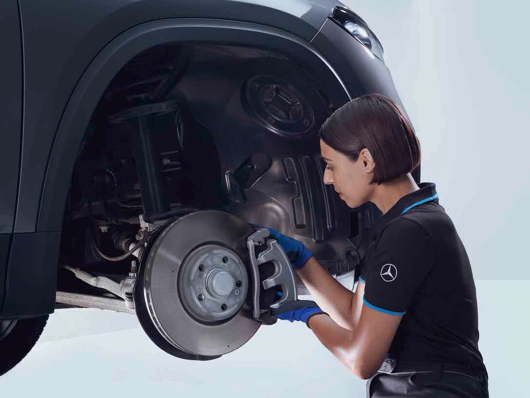 Een Mercedes-Benz technicus controleert de remmen van een auto.