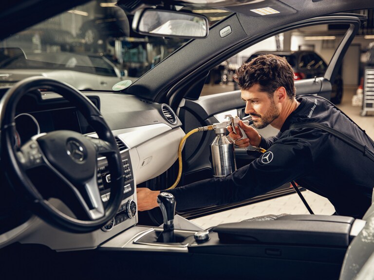 Een Mercedes-Benz technicus reinigt de airconditioning.