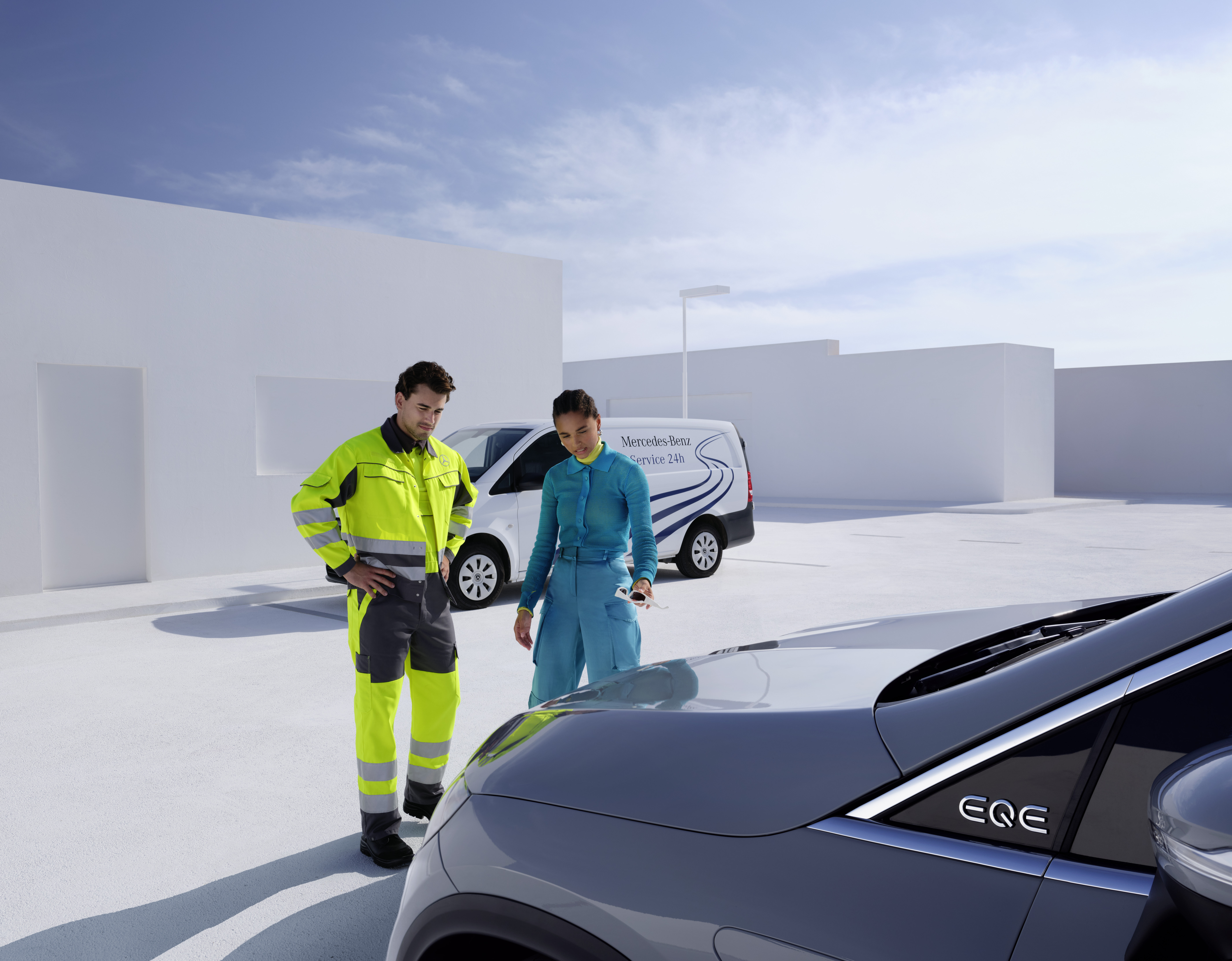 Roadside Assistance | Mercedes-Benz Een monteur van het Mercedes-Benz serviceteam en een persoon die een Mercedes-Benz bekijkt.