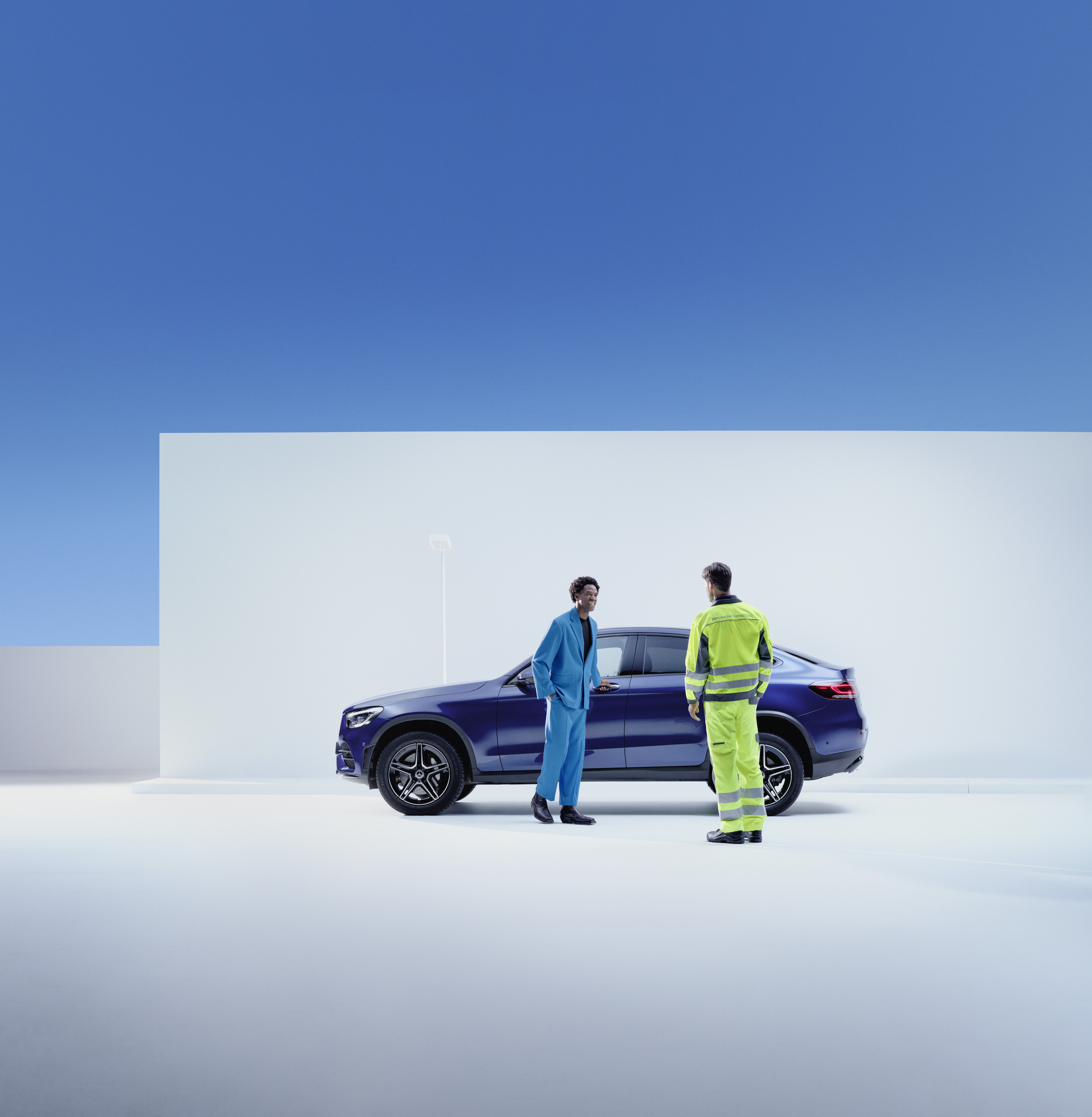 Roadside Assistance | Mercedes-Benz Een Mercedes-Benz servicemedewerker staat naast een klant aan de kant van zijn Mercedes-Benz.