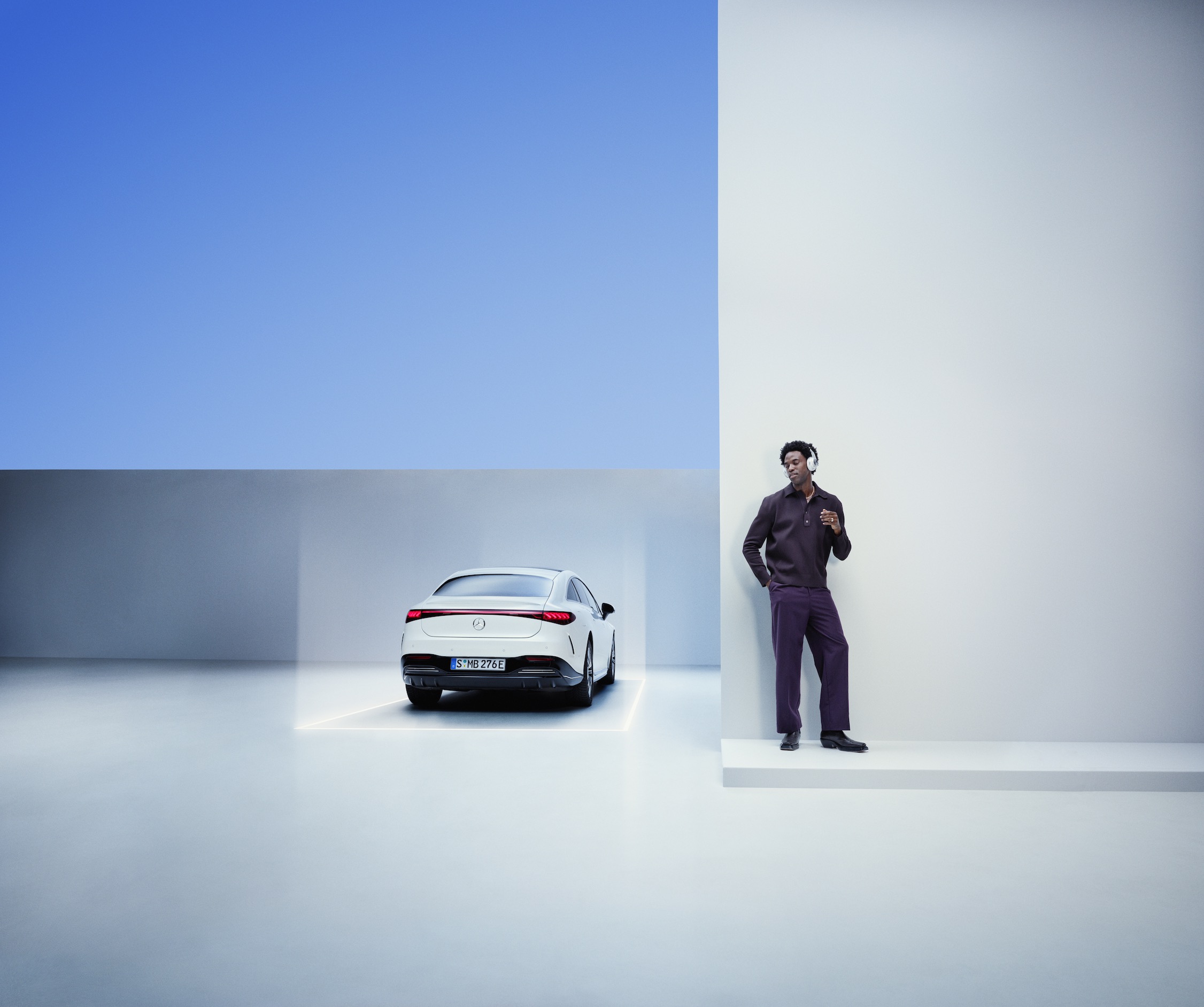 Mercedes-Benz ServiceCare Een man leunt tegen een muur naast een Mercedes-Benz.