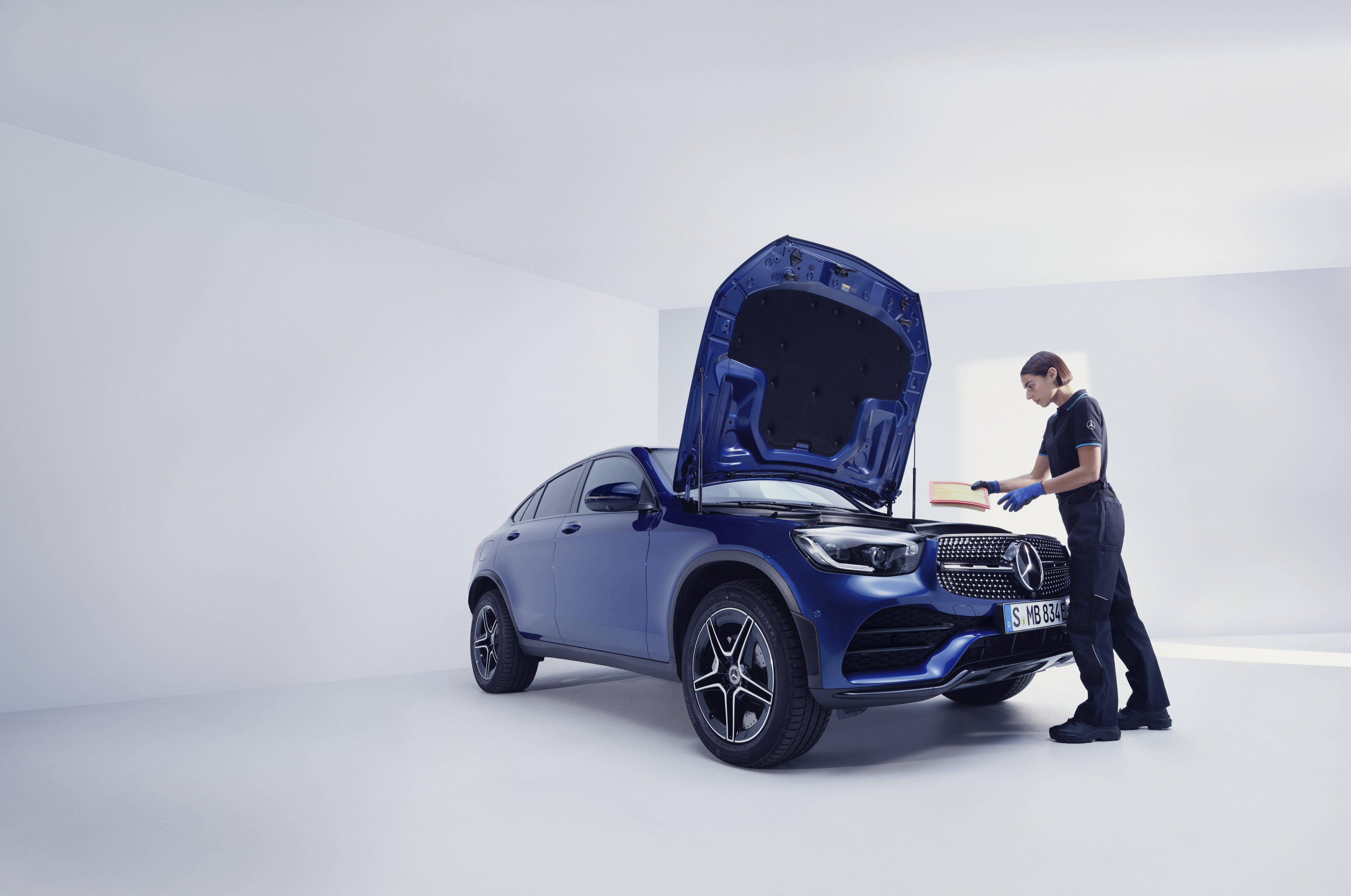 Mercedes-Benz onderhoudsservices Een Mercedes-Benz technicus en een man staan voor de geopende motorkap van een Mercedes-Benz.