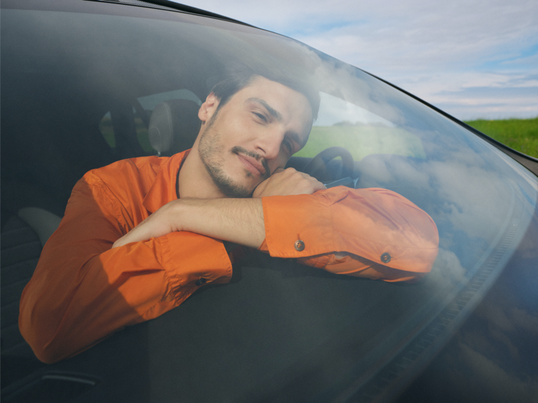Een jonge man ontspant zich in zijn Mercedes-Benz.