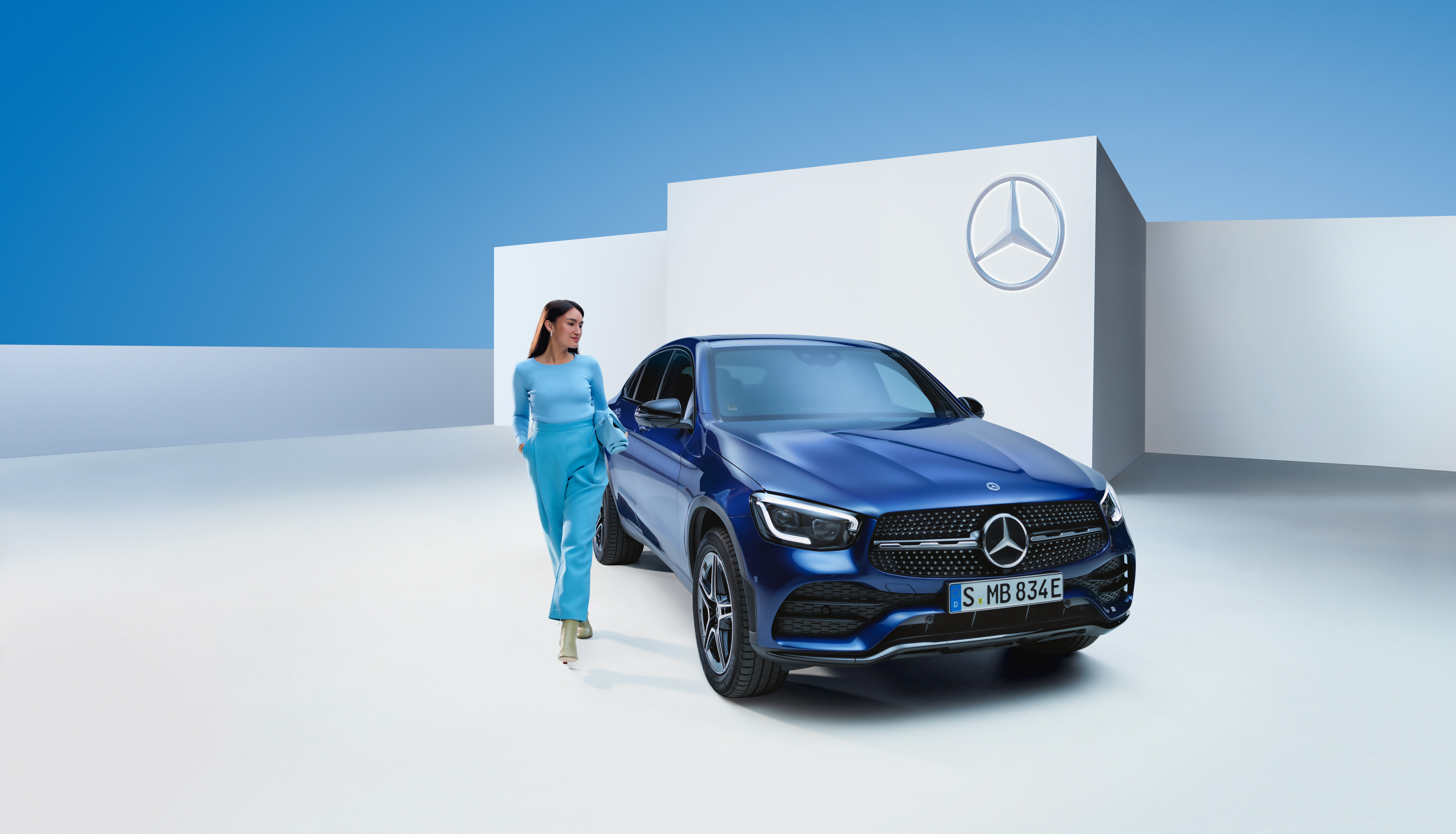 Gerust instappen met de Mercedes-Benz garantie. | Mercedes-Benz Een ontspannen vrouw naast haar Mercedes-Benz.