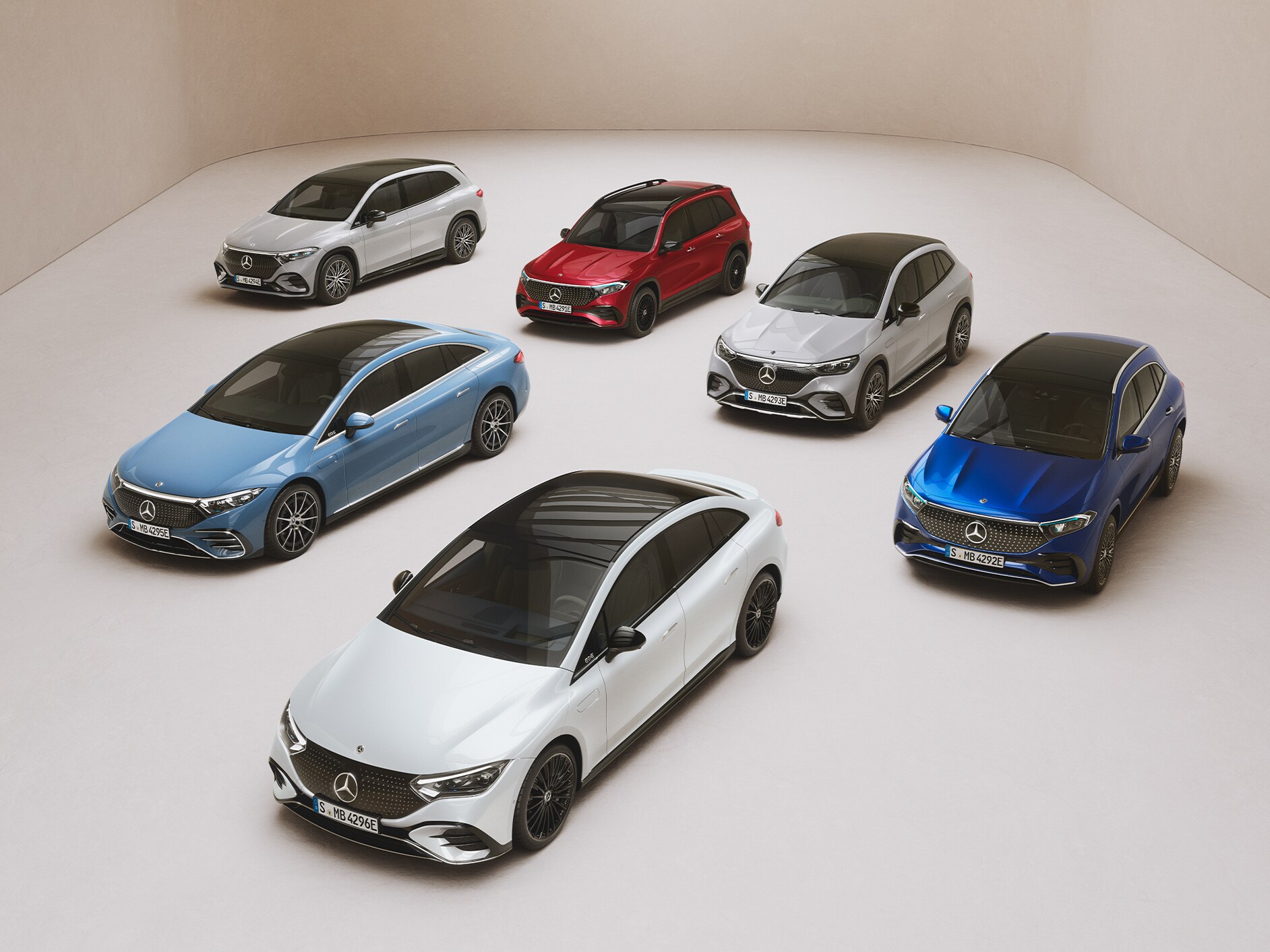 De modellen van de EQS Limousine, EQE Limousine, EQA, EQB en EQC staan geparkeerd op een spiegeloppervlak.