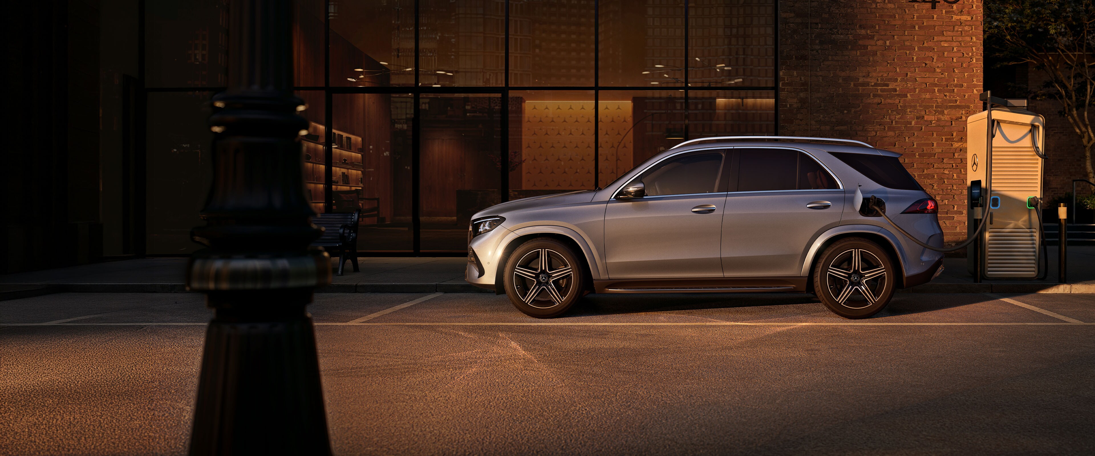 De Mercedes-Benz GLE SUV in zijaanzicht voor een groot huis.