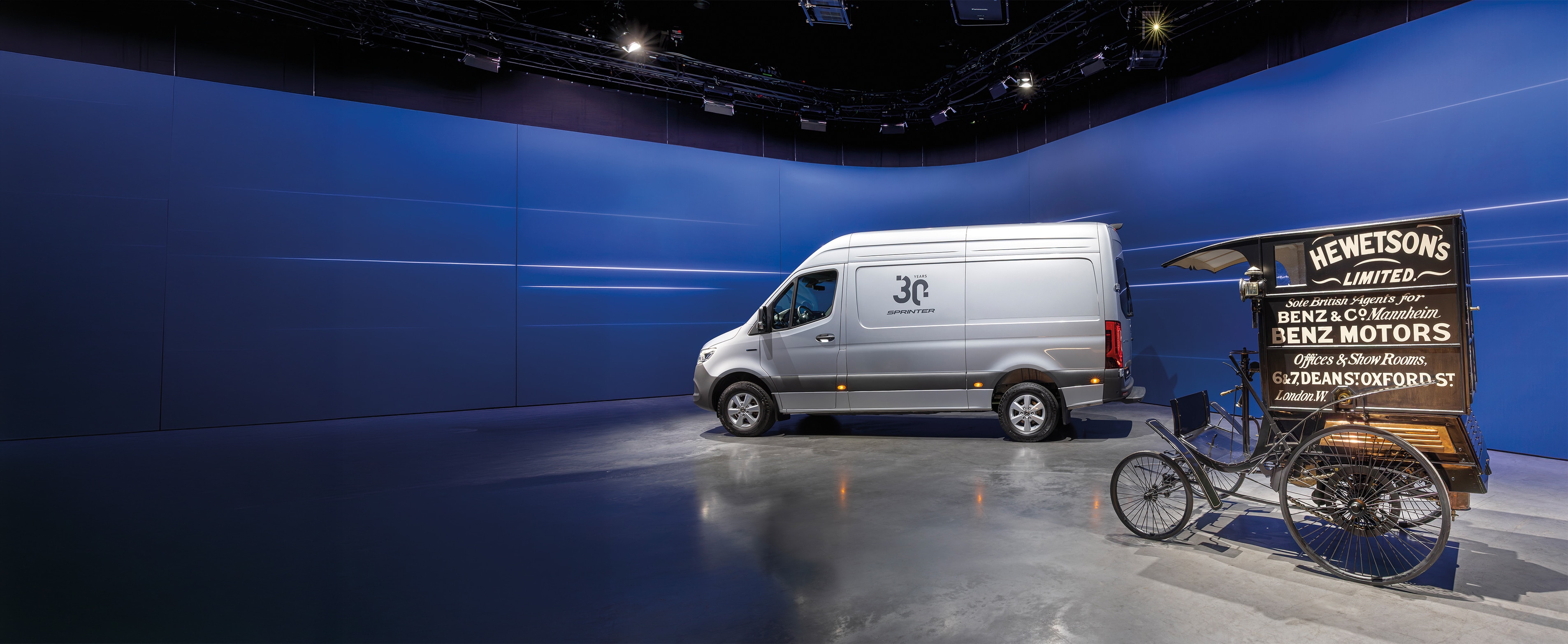 Geschiedenis | Bedrijfswagens | Mercedes-Benz Mercedes-Benz Sprinter-bestelwagen en historisch Benz-besteldienstvoertuig tentoongesteld in een moderne showroom