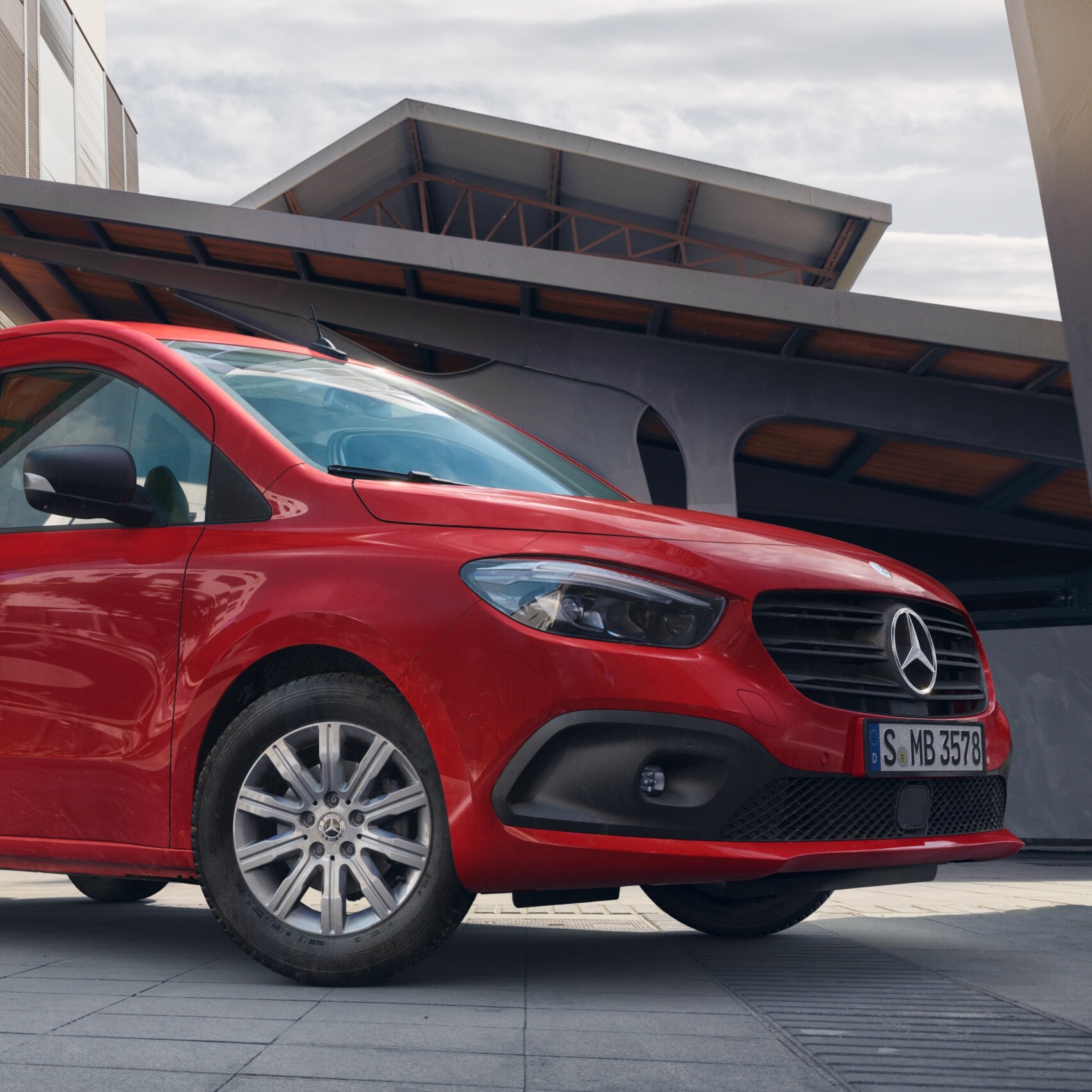 De Citan Gesloten Bestelwagen, een bestelwagen van Mercedes-Benz, is voor een logistiek terrein te zien.