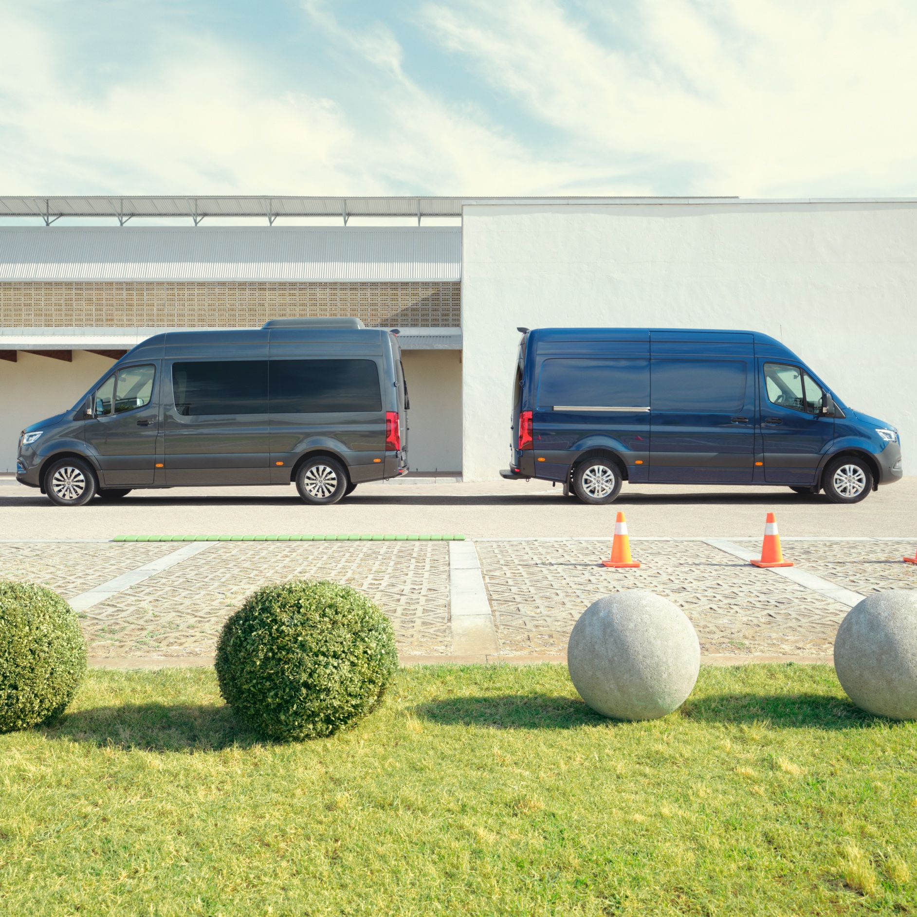 Contact | Sprinter | Mercedes-Benz De Mercedes-Benz Sprinter Tourer en Gesloten Bestelwagen op een parkeerplaats.