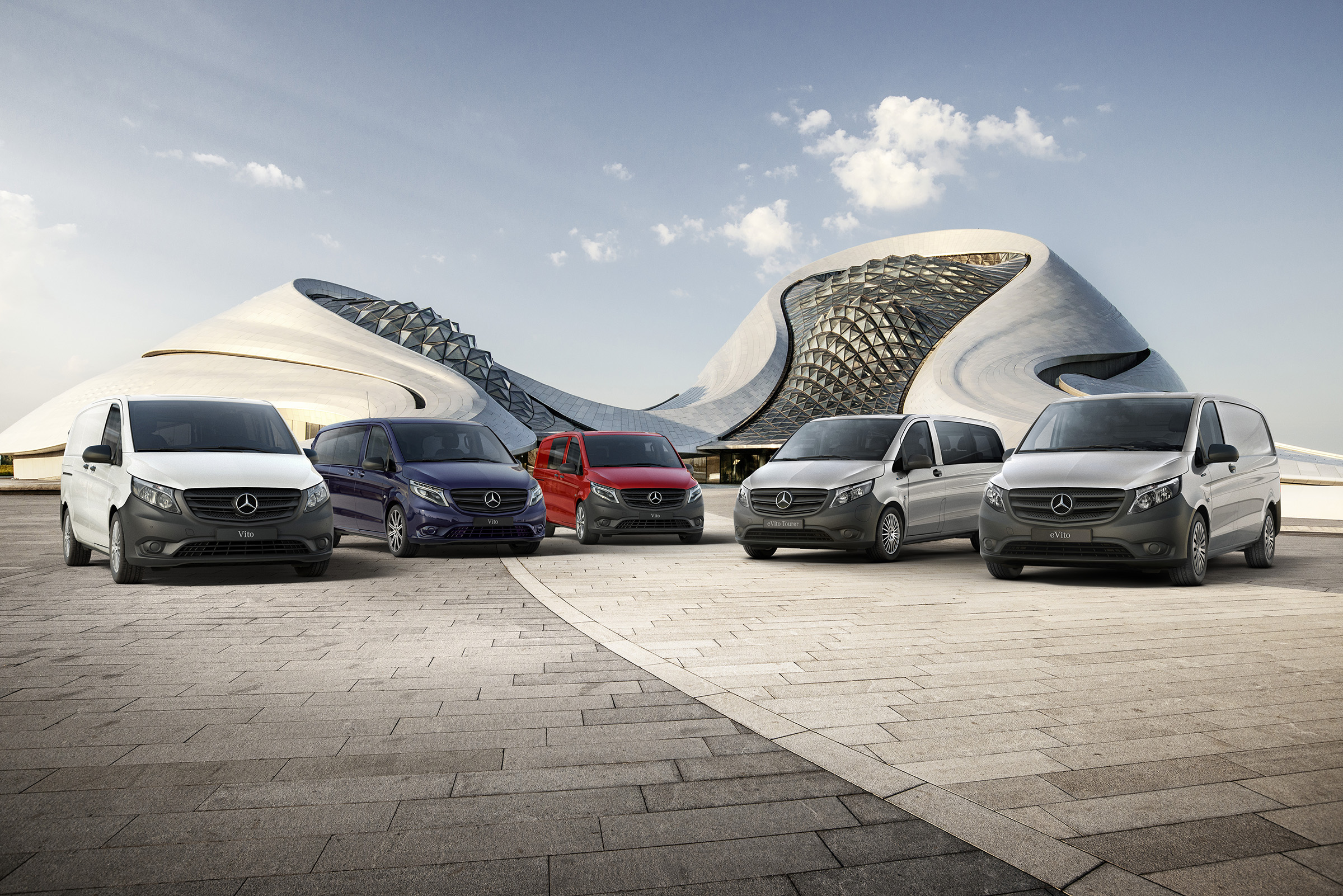 Vito-serie | Alle Vito-modellen | Bestelwagens van Mercedes-Benz De Mercedes-Benz eVito Gesloten bestelwagen, de Vito Gesloten bestelwagen, de Vito Mixto, de eVito Tourer en de Vito Tourer staan naast elkaar voor een futuristisch gebouw