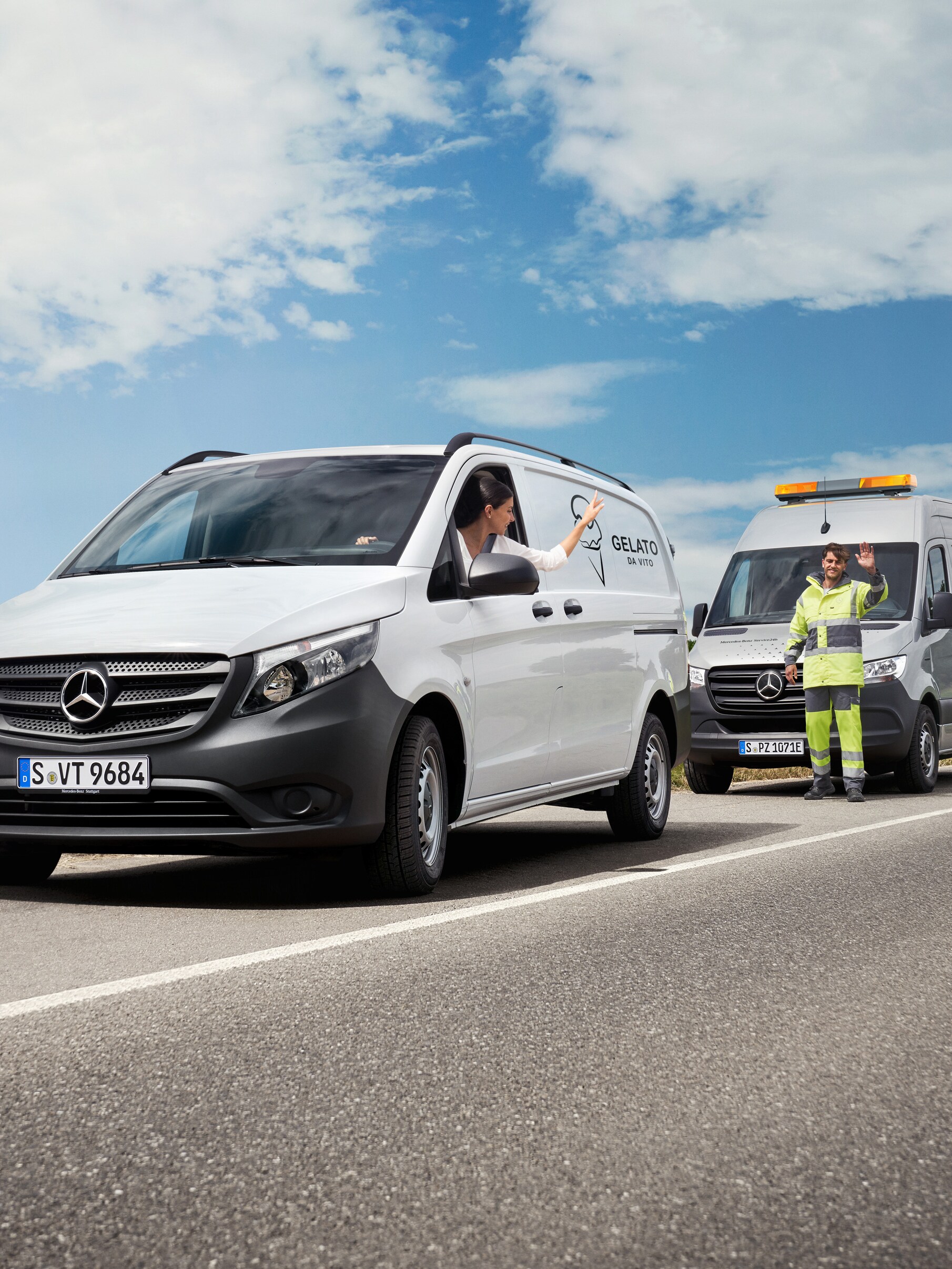 Deskundige ondersteuning onderweg: Mercedes-Benz Service helpt een Bedrijfswagenchauffeur langs de weg, beiden zwaaien vriendelijk.