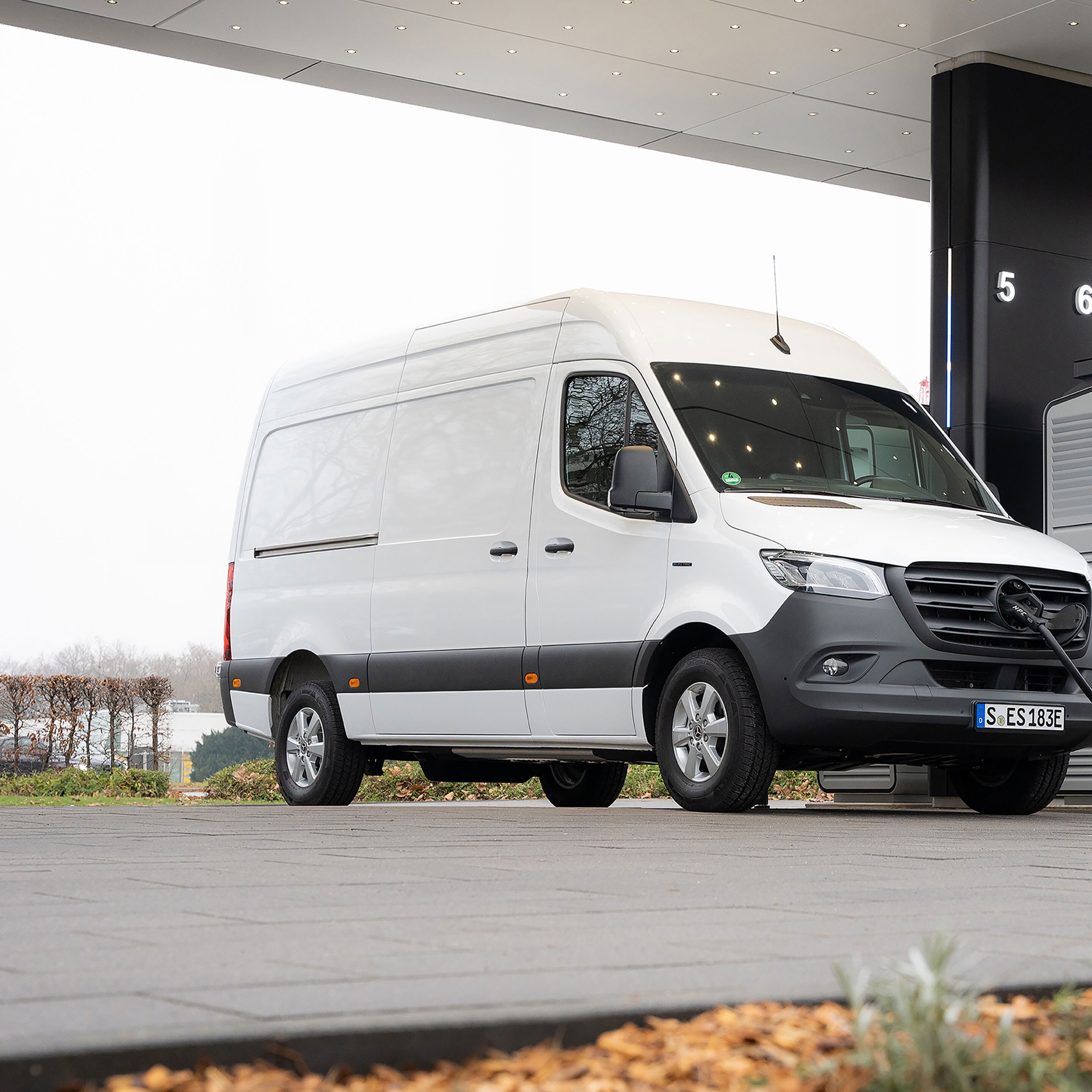 Een Mercedes-Benz bestelwagen voor een laadstation tijdens het opladen.