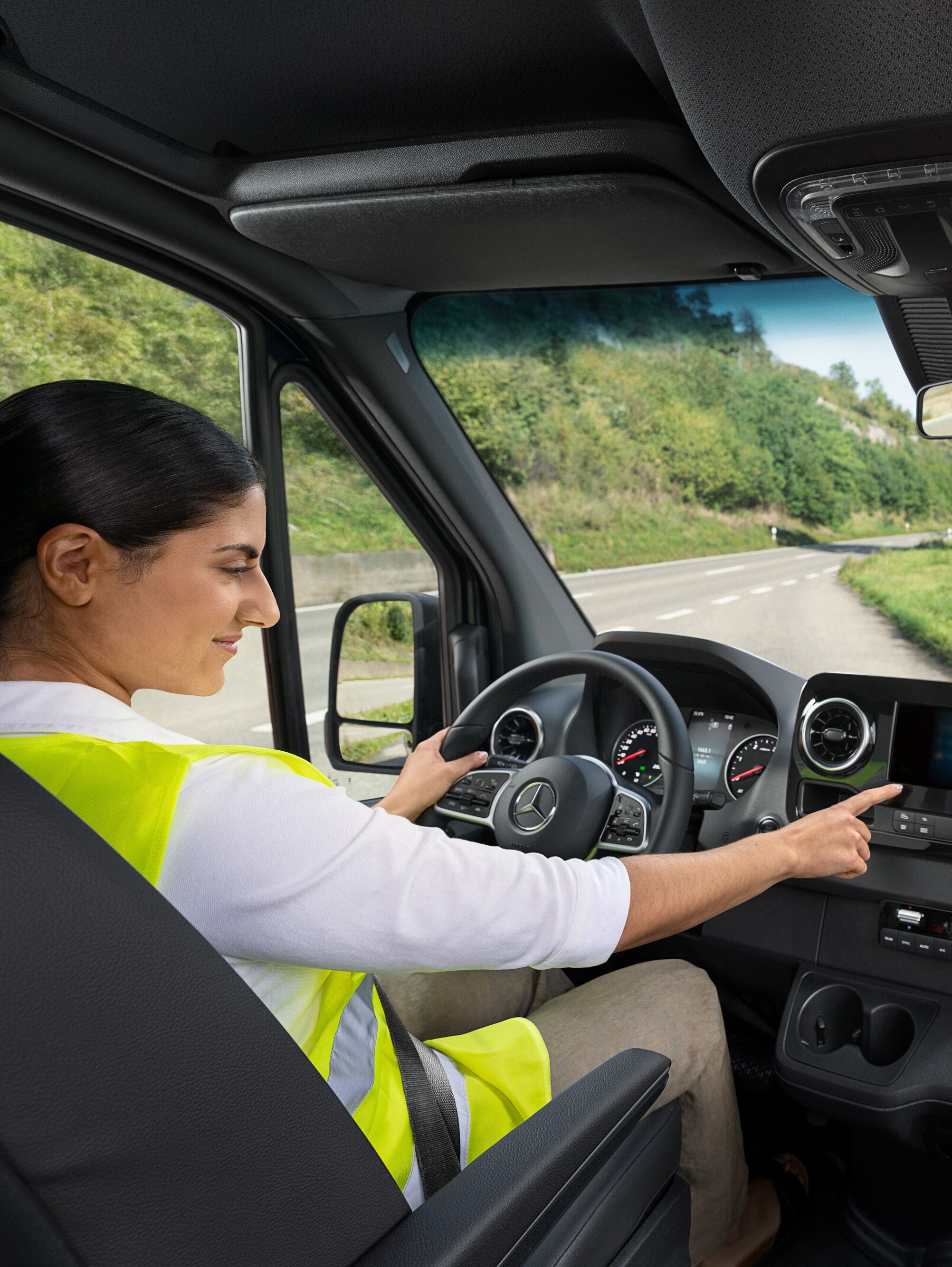 Bestuurster controleert display in haar Mercedes-Benz bedrijfswagen als onderdeel van MobiloVan service.