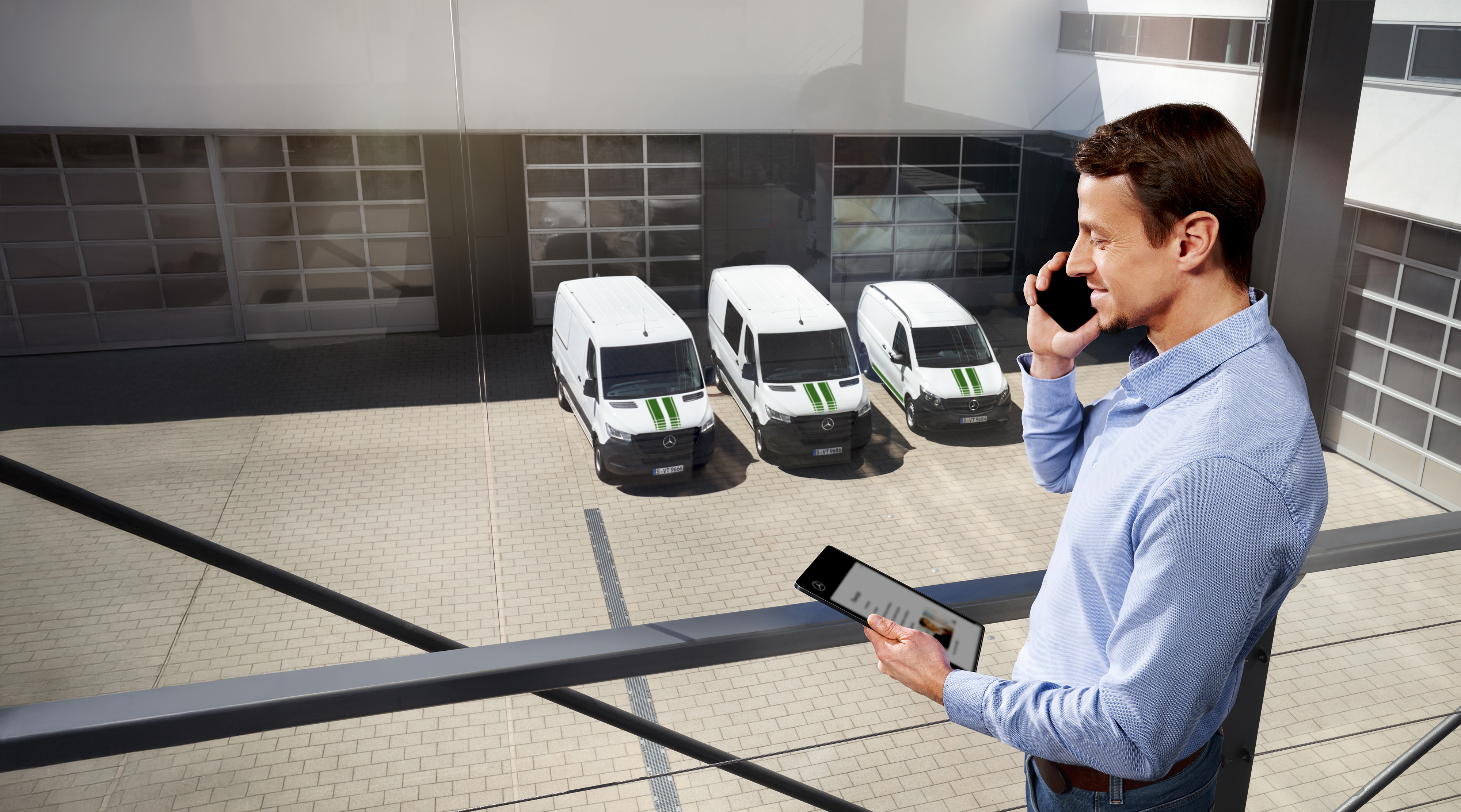 Mercedes-Benz Bedrijfswagens | MobiloVan mobiliteitsgarantie Klant aan de telefoon voor een vloot witte Mercedes-Benz Bedrijfswagens, symbool voor MobiloVan.
