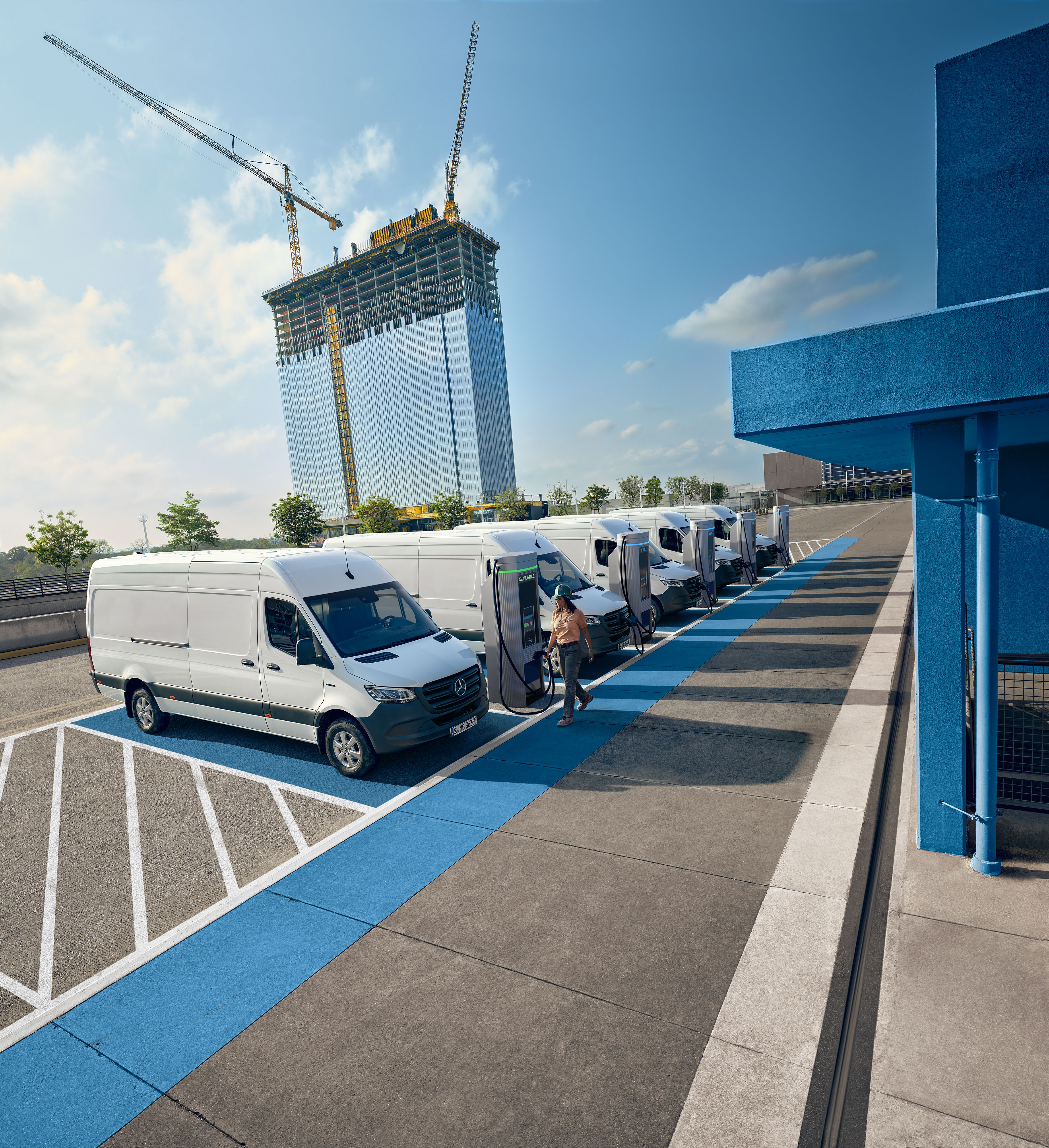 Mercedes-Benz Comfort Een vloot witte elektrische Mercedes-Benz bestelwagens geparkeerd bij een laadstation.