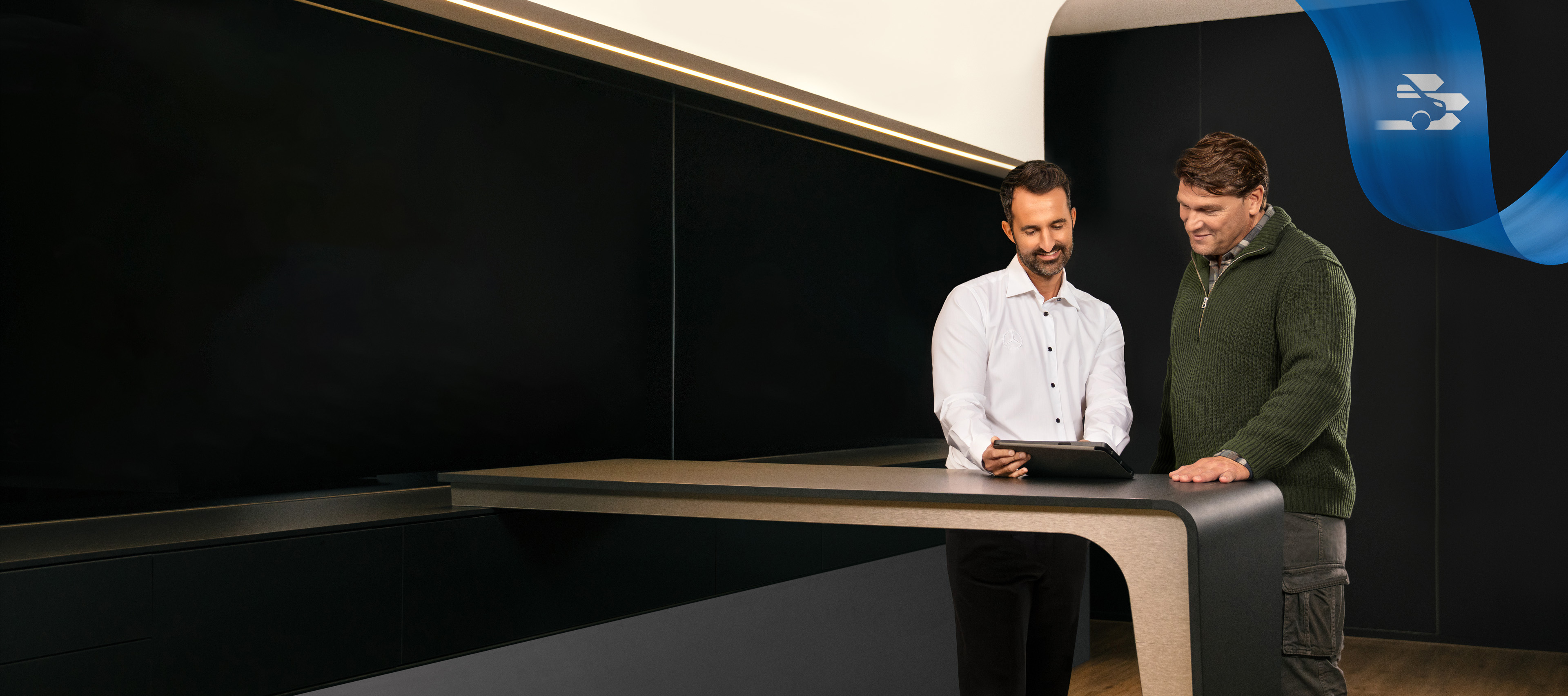 Mercedes-Benz | Comfort | Service Partner Twee mannen in een Mercedes-Benz servicepartnerkantoor die iets bespreken dat op een tablet te zien is