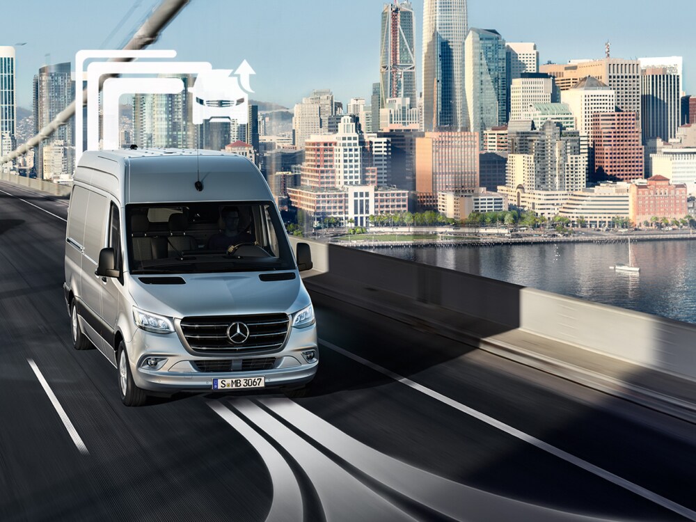Een Mercedes-Benz bestelwagen rijdt overdag over een brug met meerdere rijstroken.