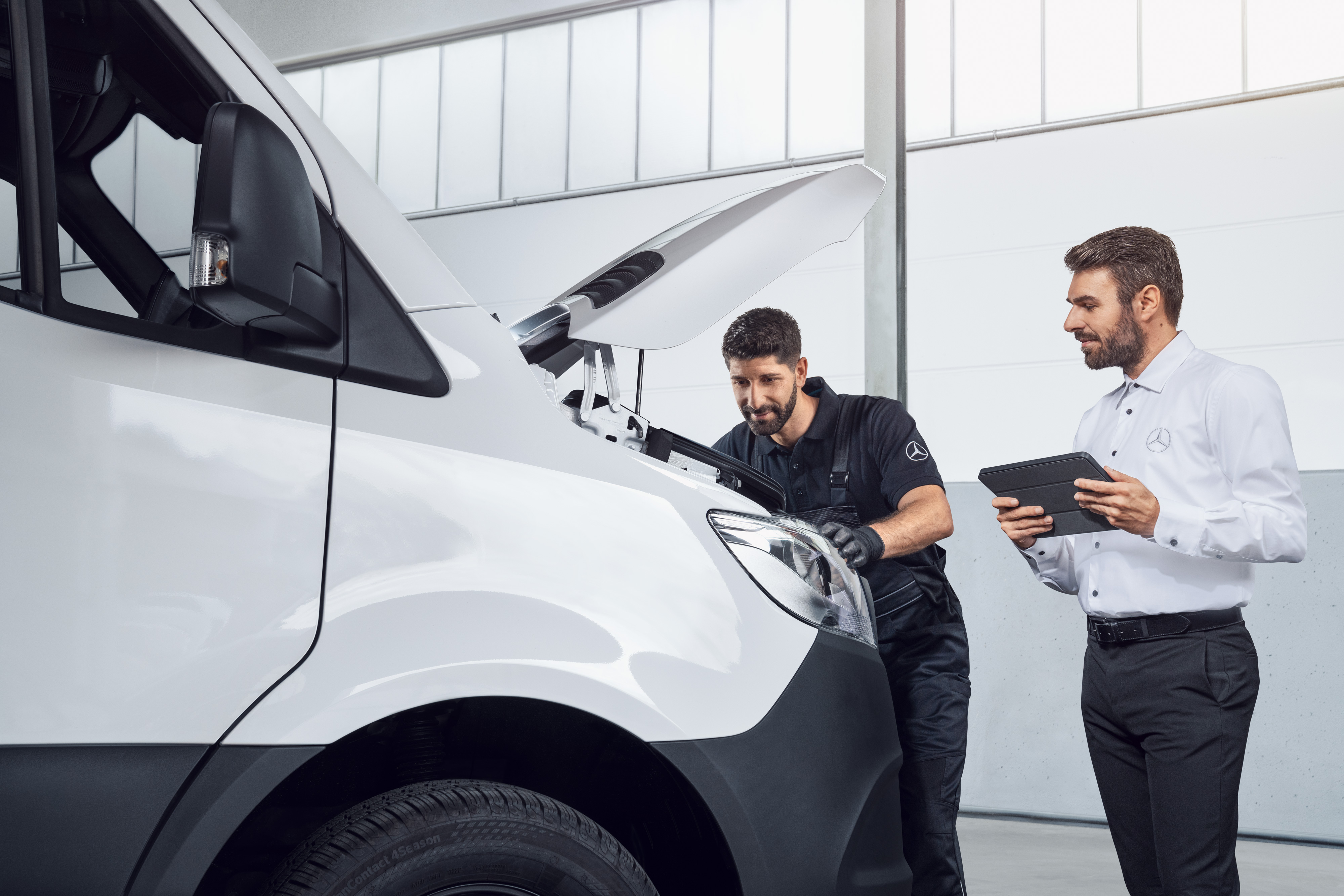 Mercedes-Benz | Vans Quality originele onderdelen Twee mannen testen een Mercedes Sprinter met tablet en open motorkap, onderwerp: Mercedes-Benz Sprinter onderdelen.
