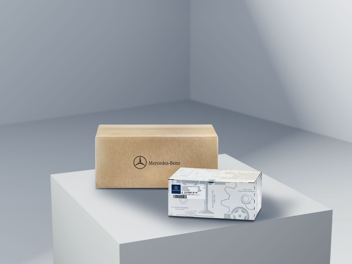 Twee pakketten met het Mercedes-Benz logo, die de originele onderdelen van Mercedes-Benz symboliseren, op een lichtgekleurd plateau.