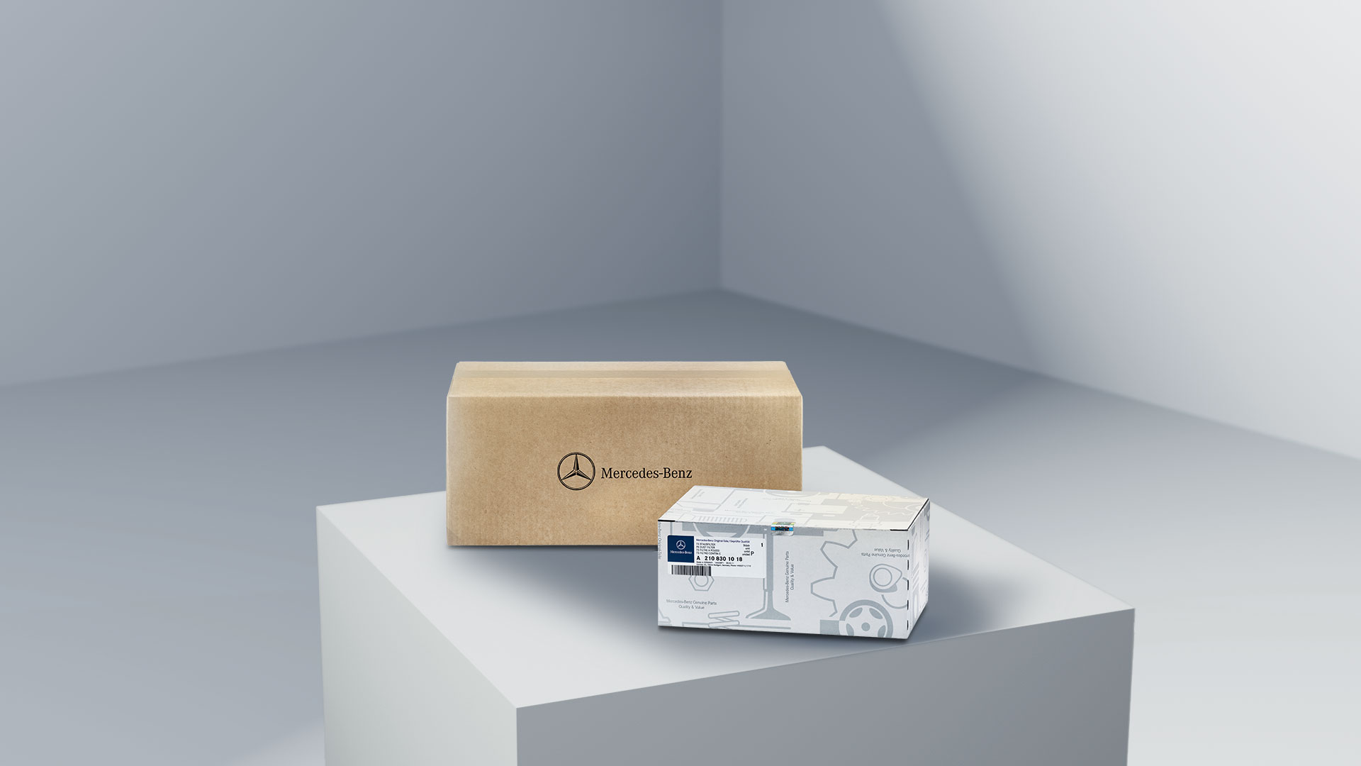 Mercedes-Benz | Vans Quality originele onderdelen Twee pakketten met het Mercedes-Benz logo, die de originele onderdelen van Mercedes-Benz symboliseren, op een lichtgekleurd plateau.
